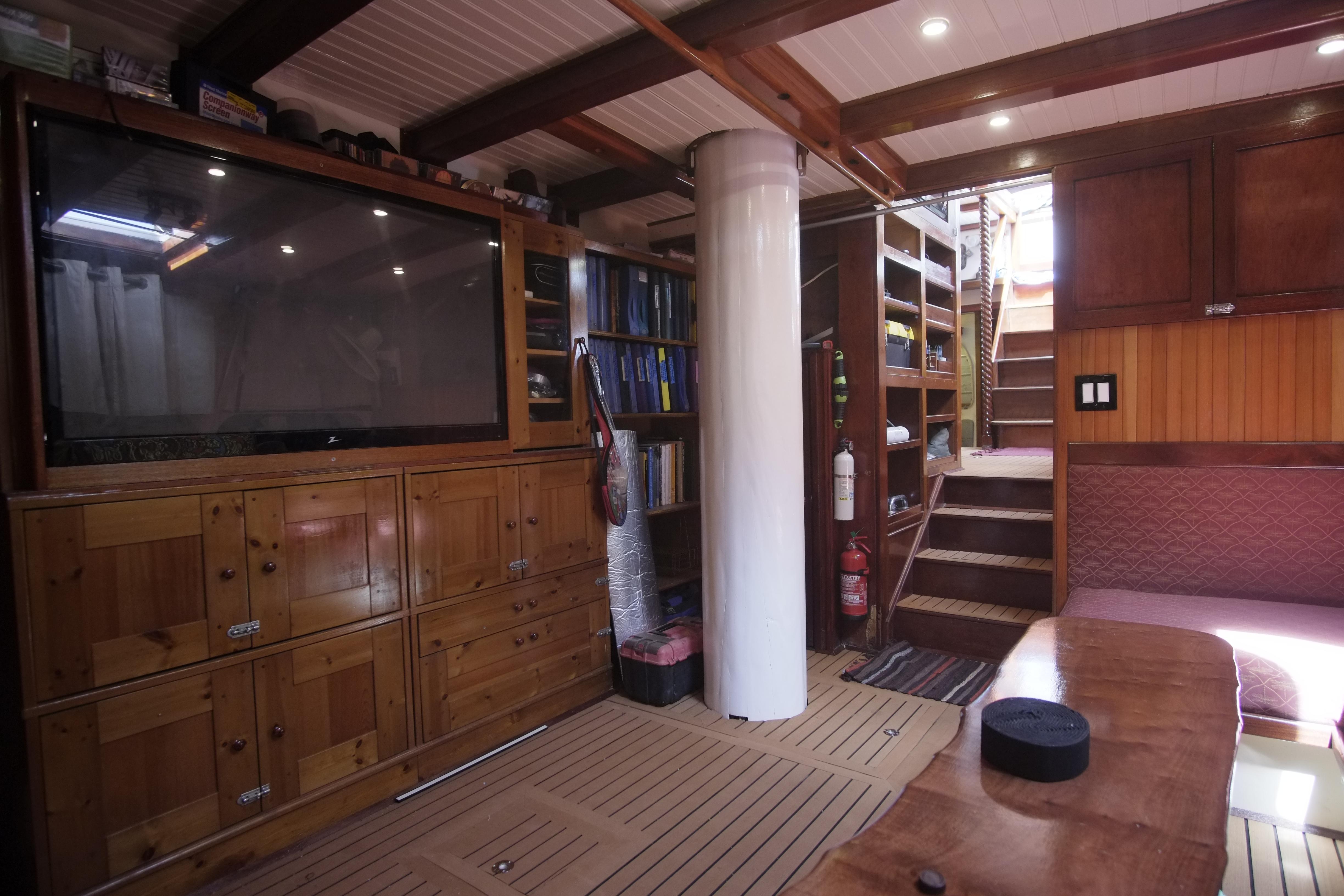 Interior of 2006 Custom Bud Macintosh schooner with wooden cabinets, stairs, and large TV.