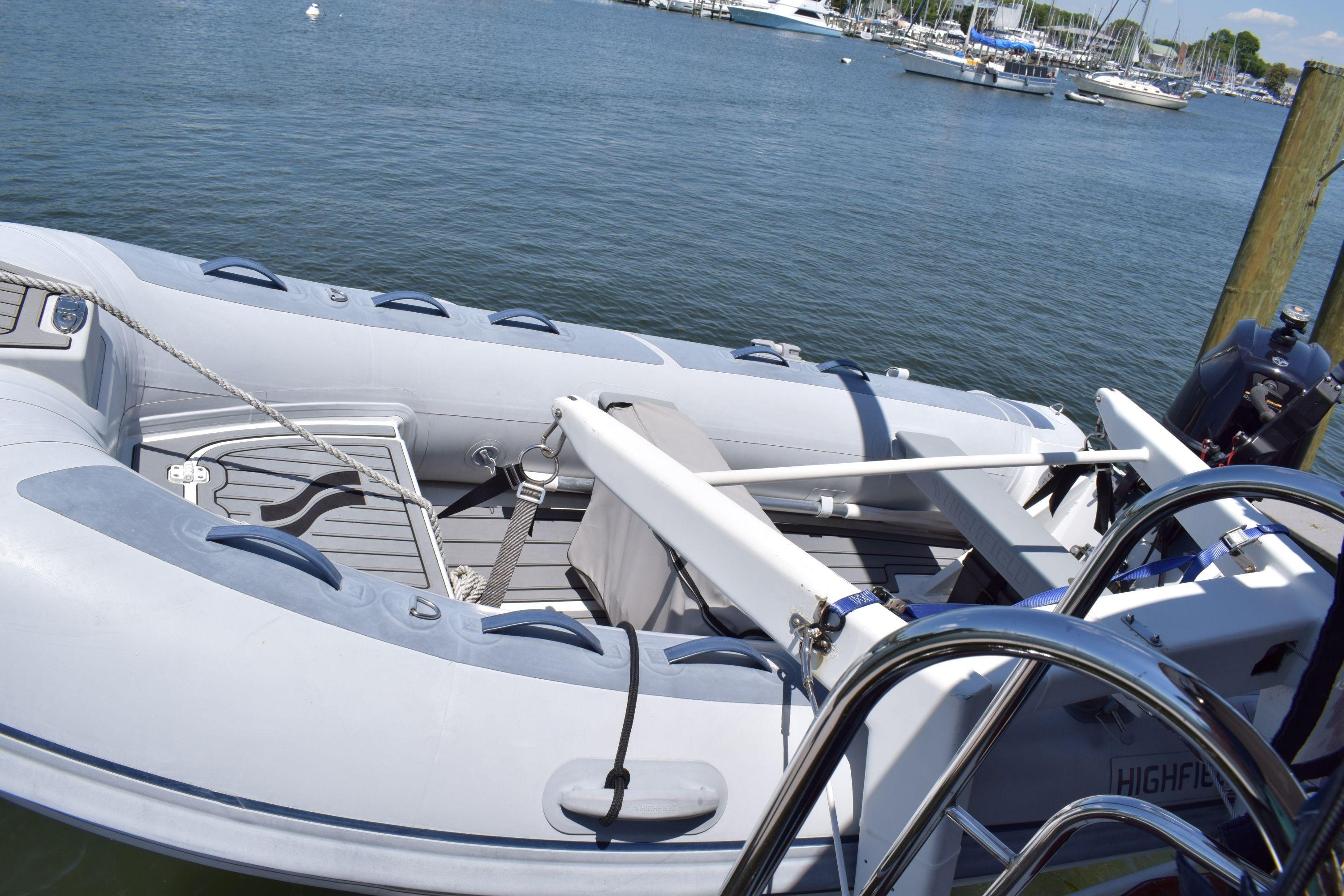 Inflatable boat docked near a Cheoy Lee 52 Motorsailer, 1980 model, on a sunny day.