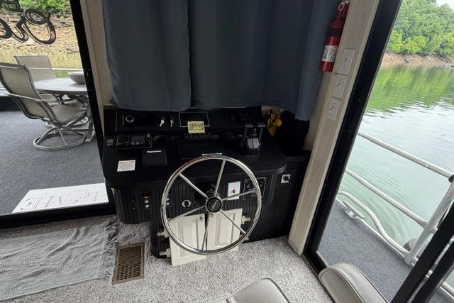 Interior helm of 1997 Stardust Houseboat 18x83 with steering wheel and controls.