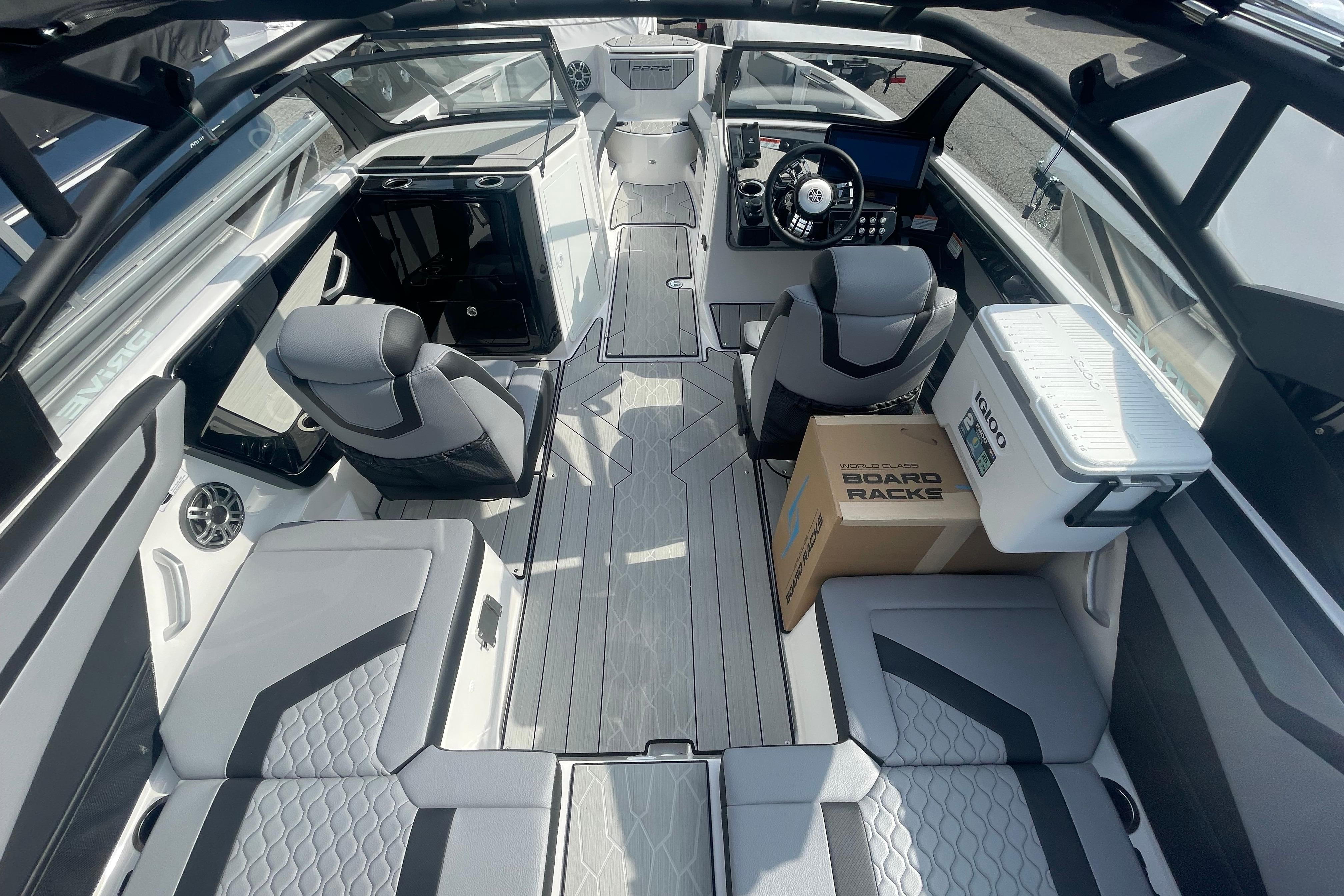 2026 Yamaha Boats 222XD interior with modern seating, steering console, and storage features.