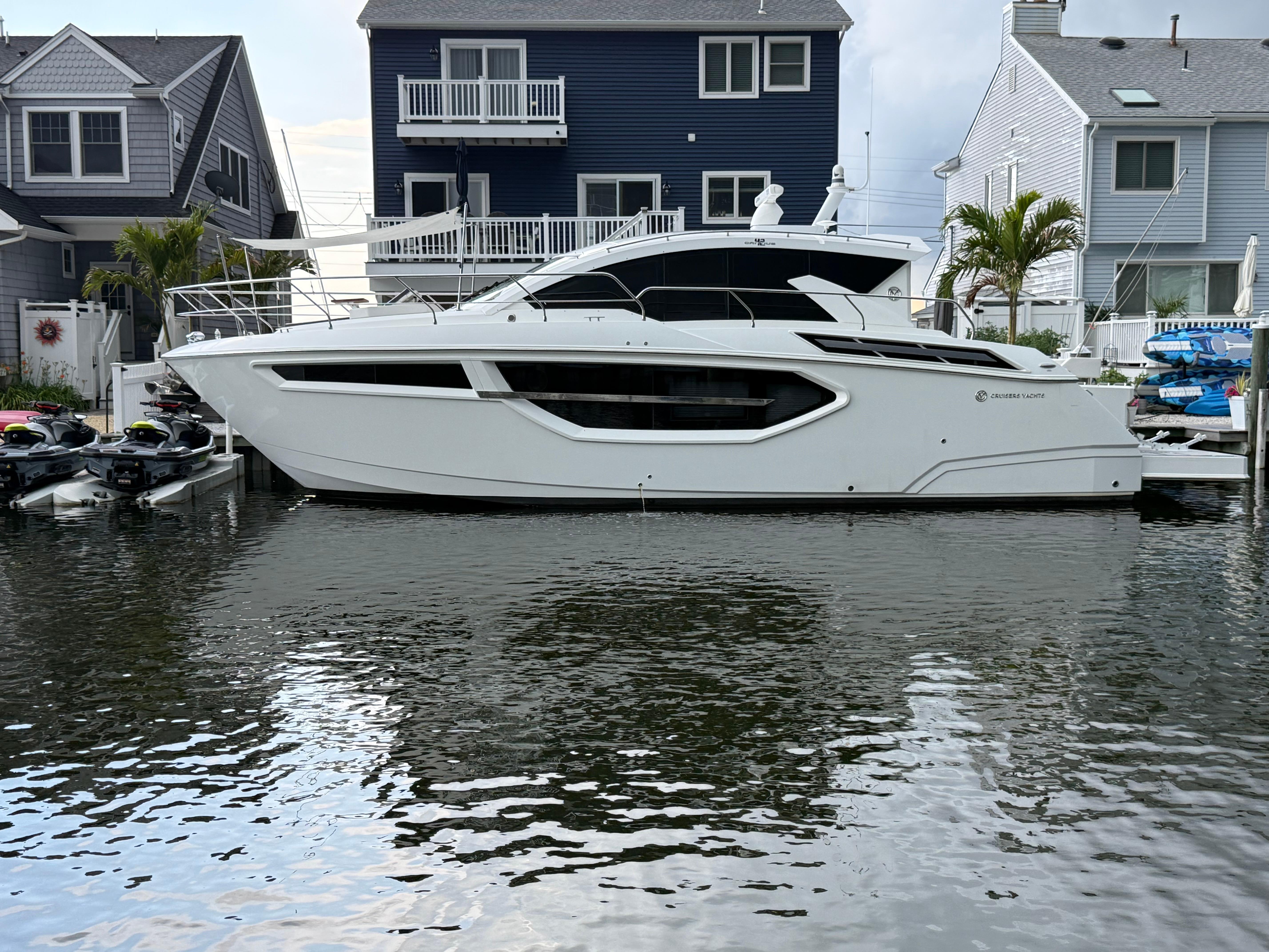 2018 Cruisers Yachts 42 Cantius docked near waterfront homes.