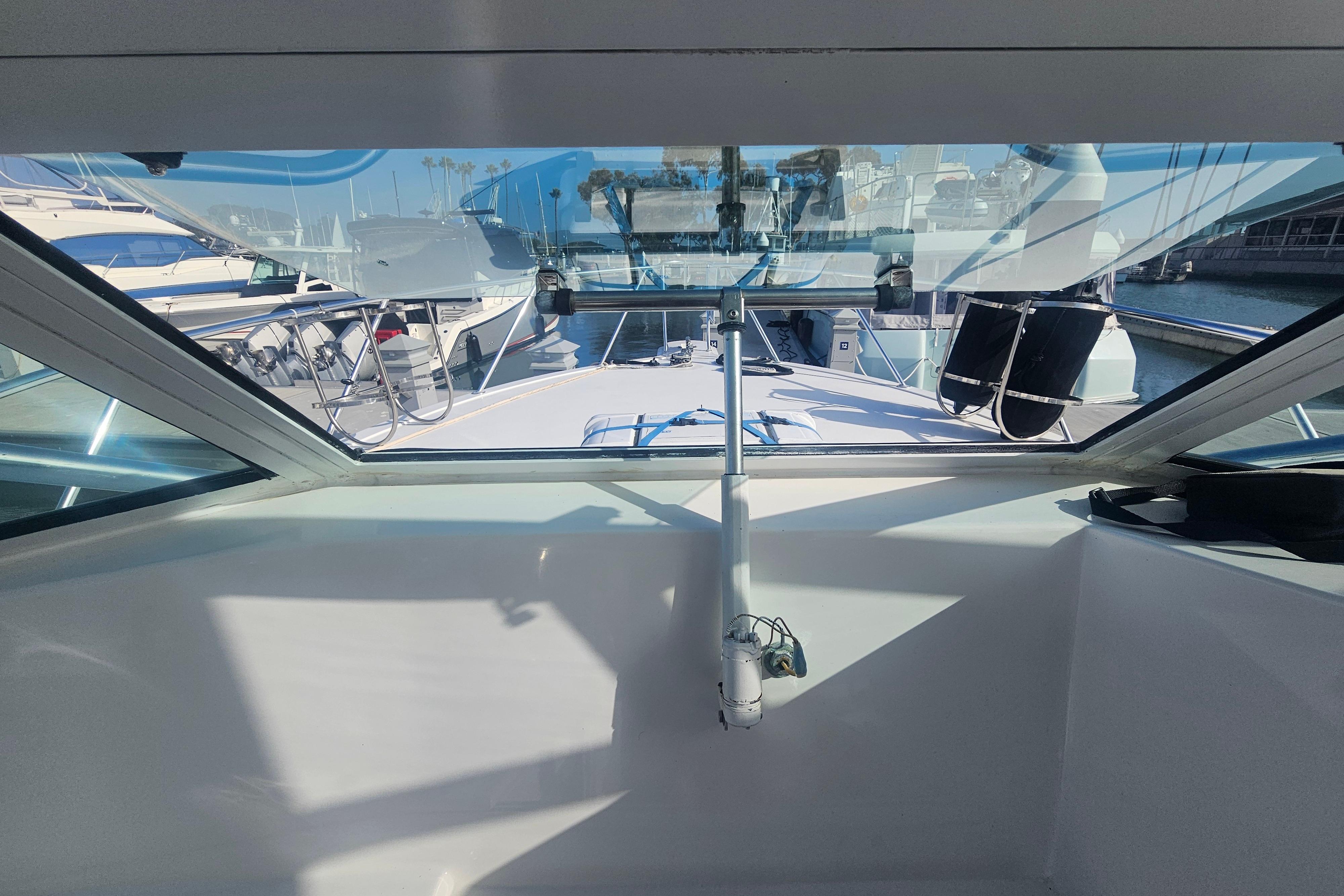 View from the helm of a 2003 Topaz 32 Express boat in a marina.
