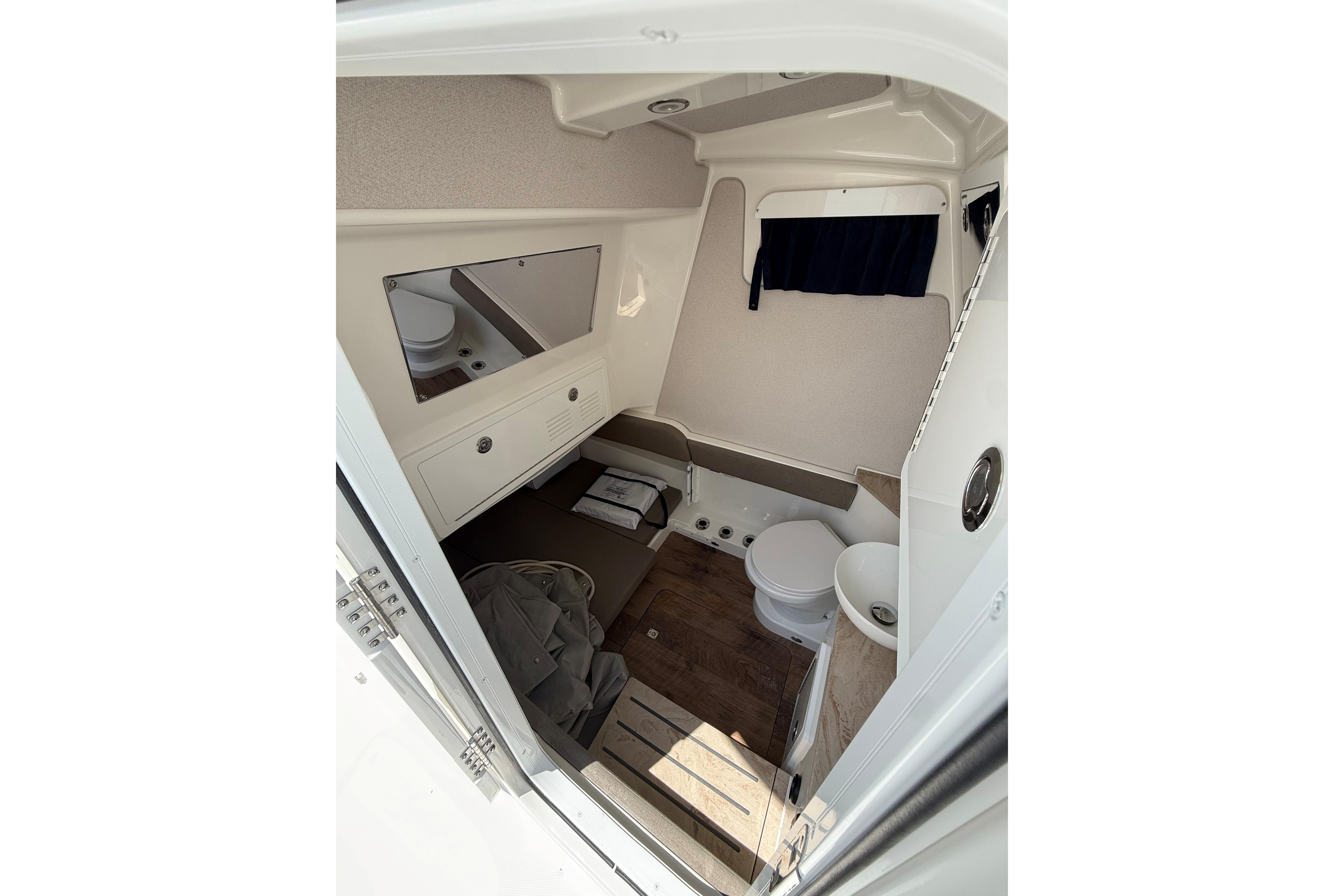 Interior cabin of 2026 Regulator 35 boat, featuring compact amenities and wooden flooring.