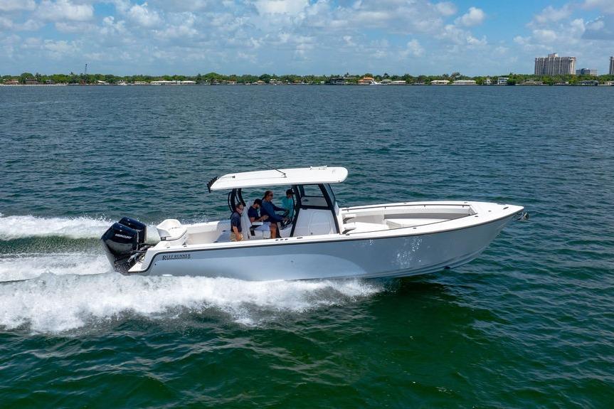 2027 Reef Runner 340 boat cruising on open water under a clear blue sky.