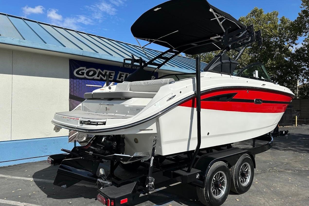 2026 Sea Ray SDX 230 Surf boat on trailer, featuring sleek design and vibrant red accents.