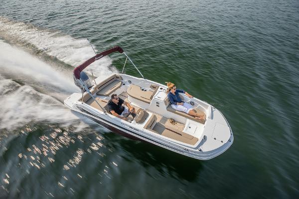 2025 Hurricane SunDeck Sport 205 OB cruising on open water, showcasing sleek design and performance.