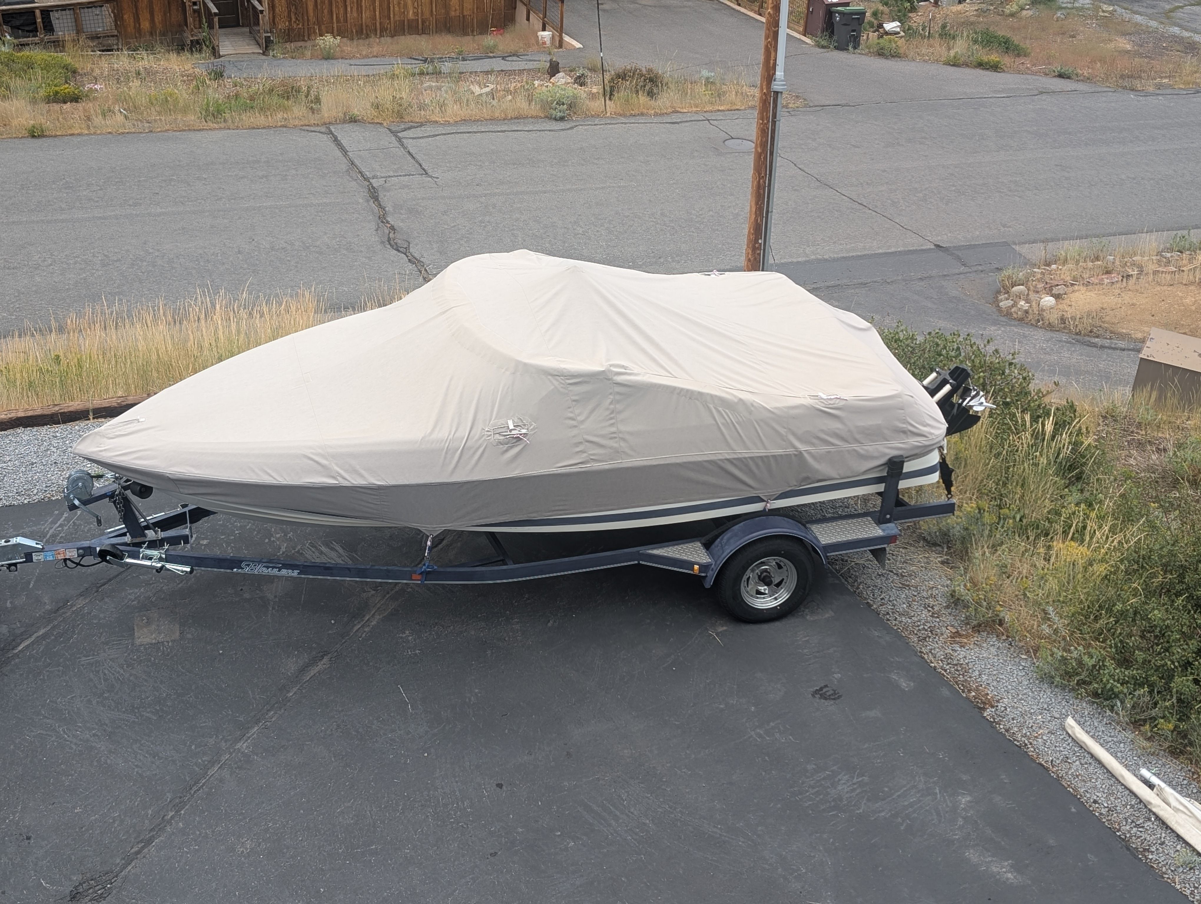 A 1997 Cobalt 190 boat on a trailer, covered with a tarp.