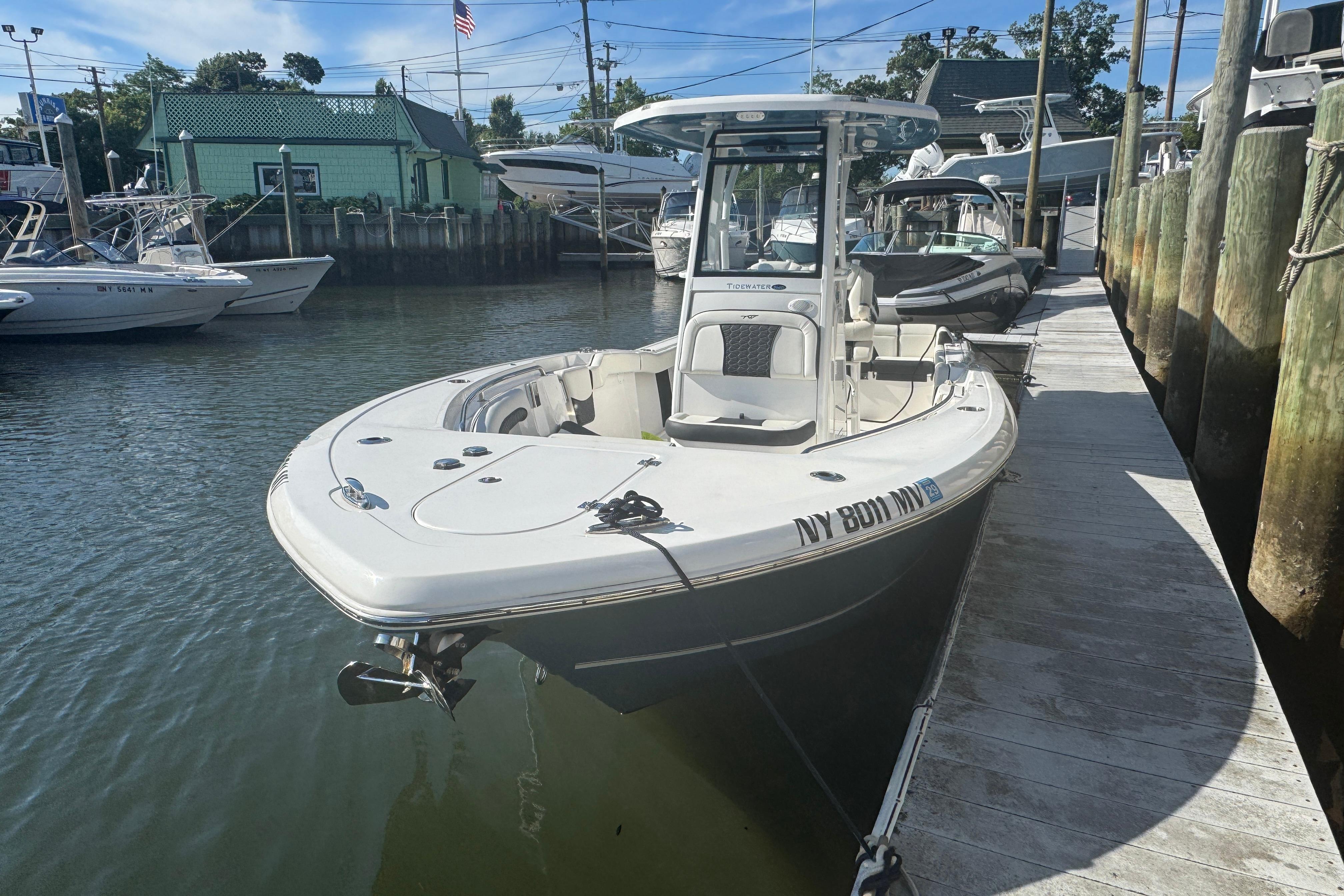 2025 Tidewater 232 LXF boat docked at marina, sunny day, calm water.