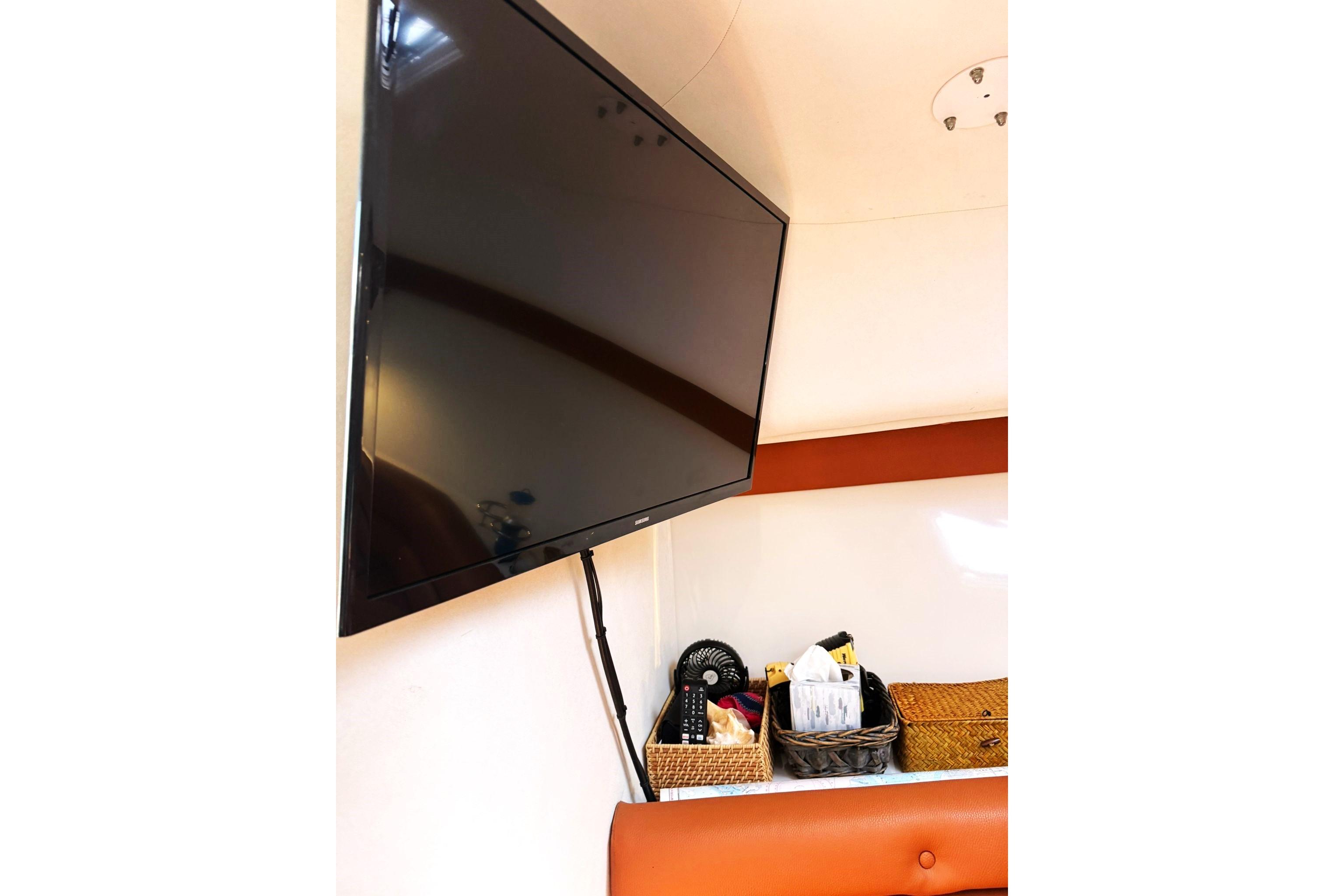 Flat-screen TV and storage baskets inside 2006 Pro-Line 32 Express boat cabin.