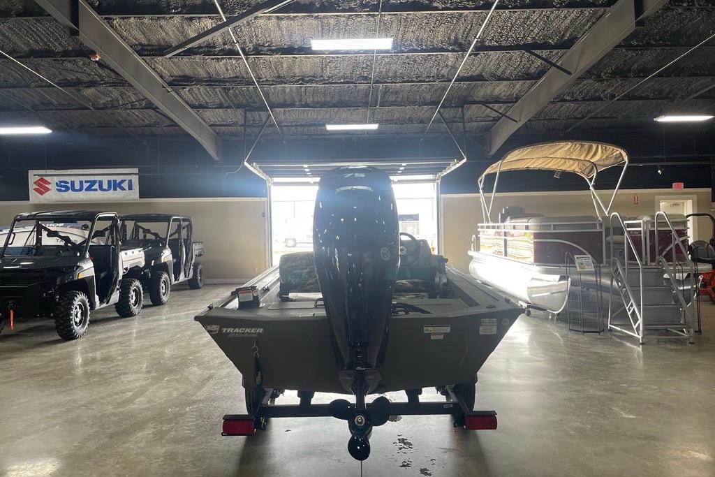 2026 Tracker Grizzly 1754 SC boat in showroom with Suzuki vehicles.