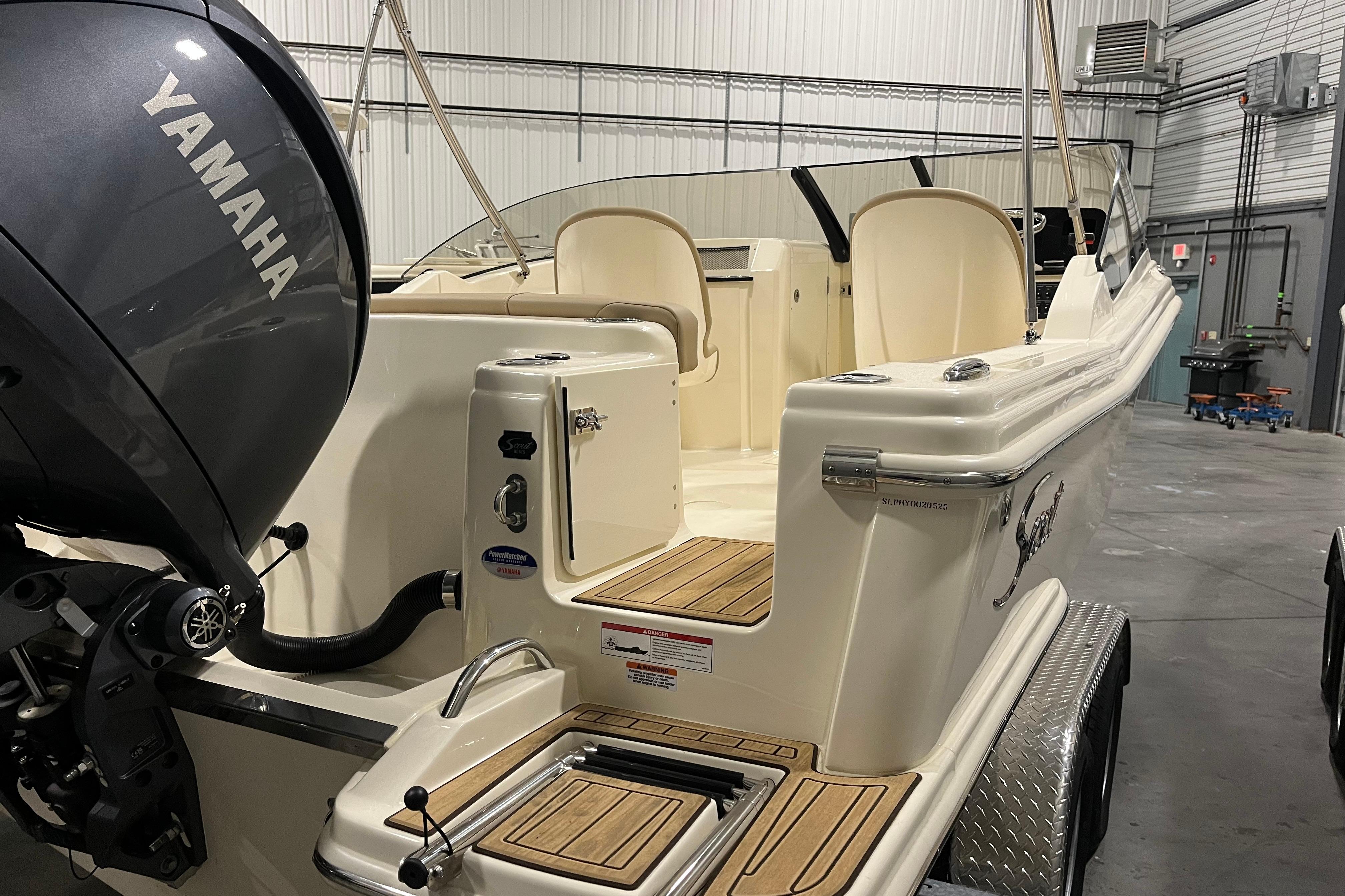 2025 Scout 215 Dorado boat with Yamaha engine in a garage setting.