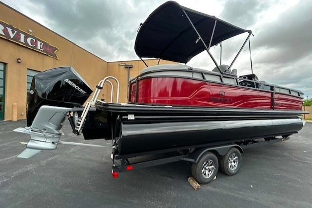 2026 Regency 250 DL pontoon boat with canopy on trailer, parked outdoors.
