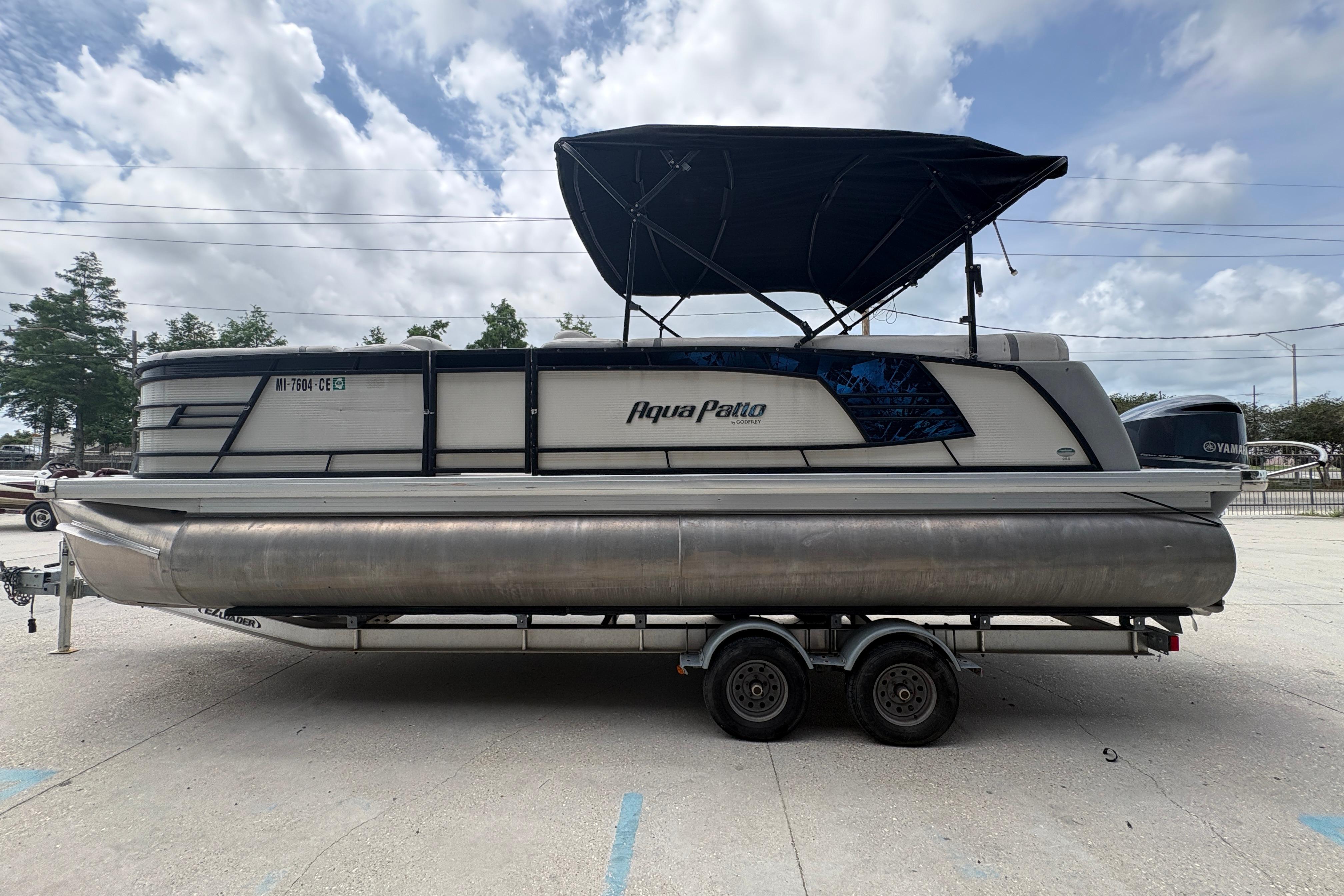 2019 Godfrey Aqua Patio pontoon boat on trailer under cloudy sky.