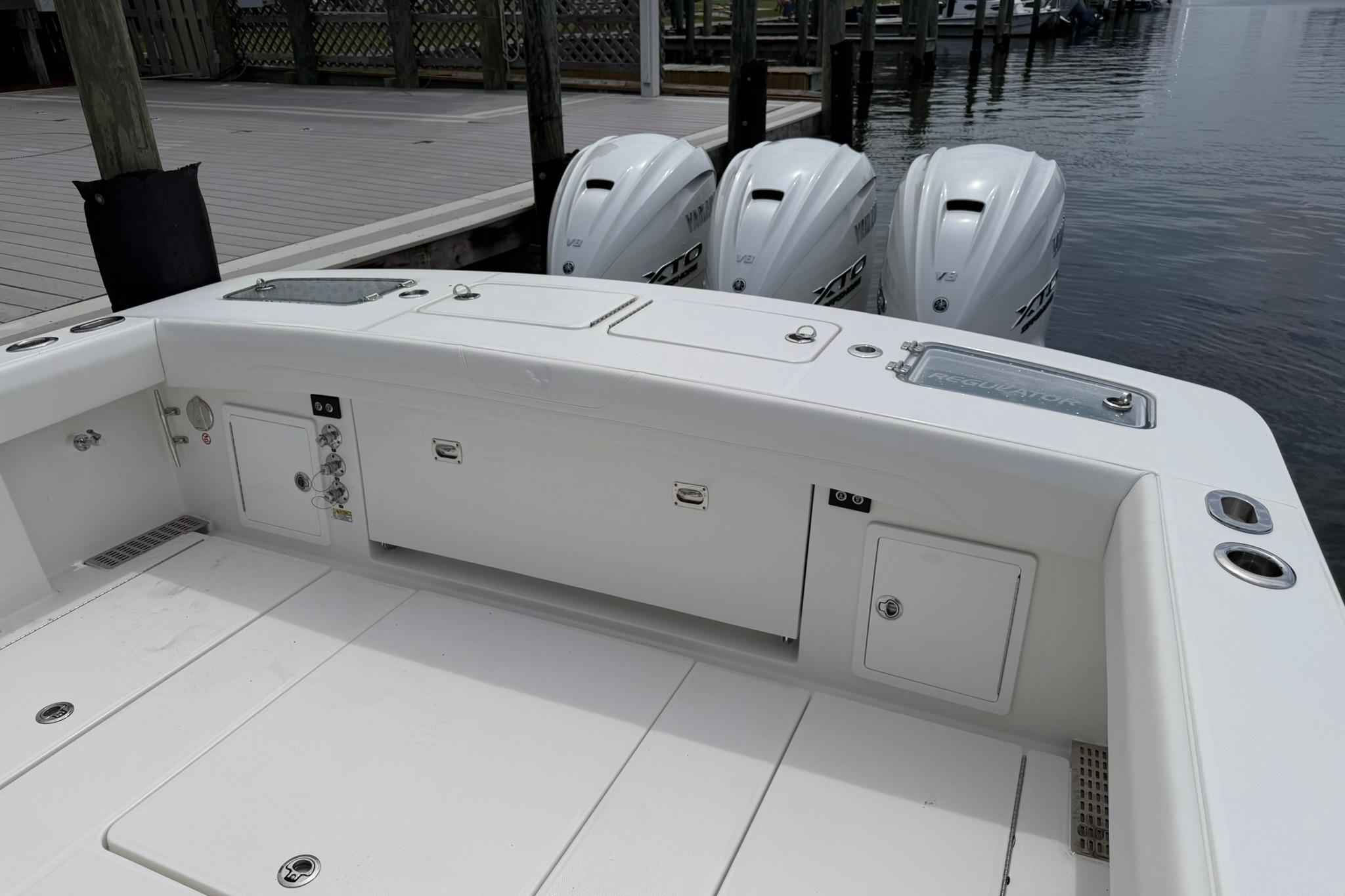 2026 Regulator 37 boat with triple outboard engines docked by the water.