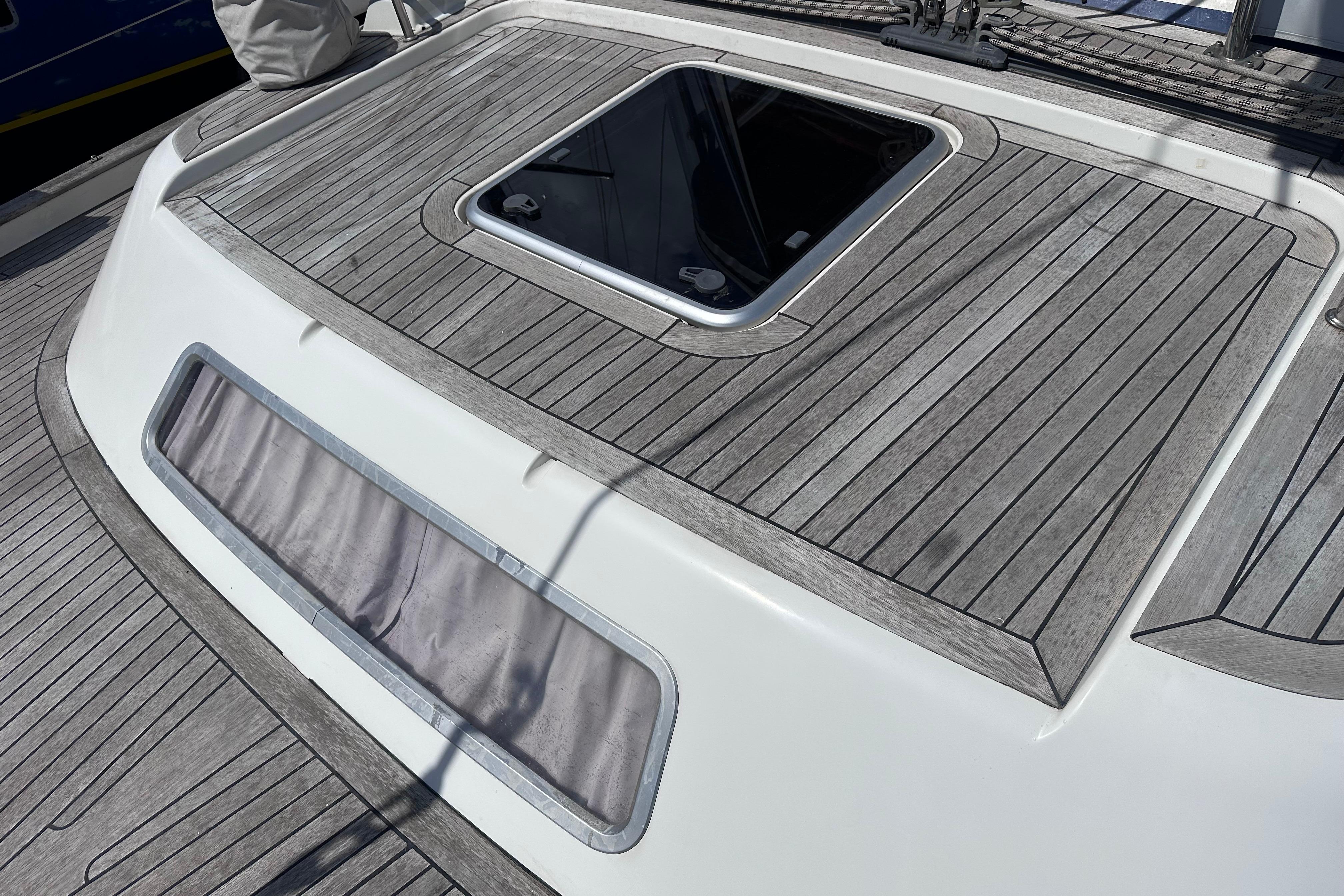 Teak deck of a 2008 Hallberg-Rassy 54 yacht with an open hatch.