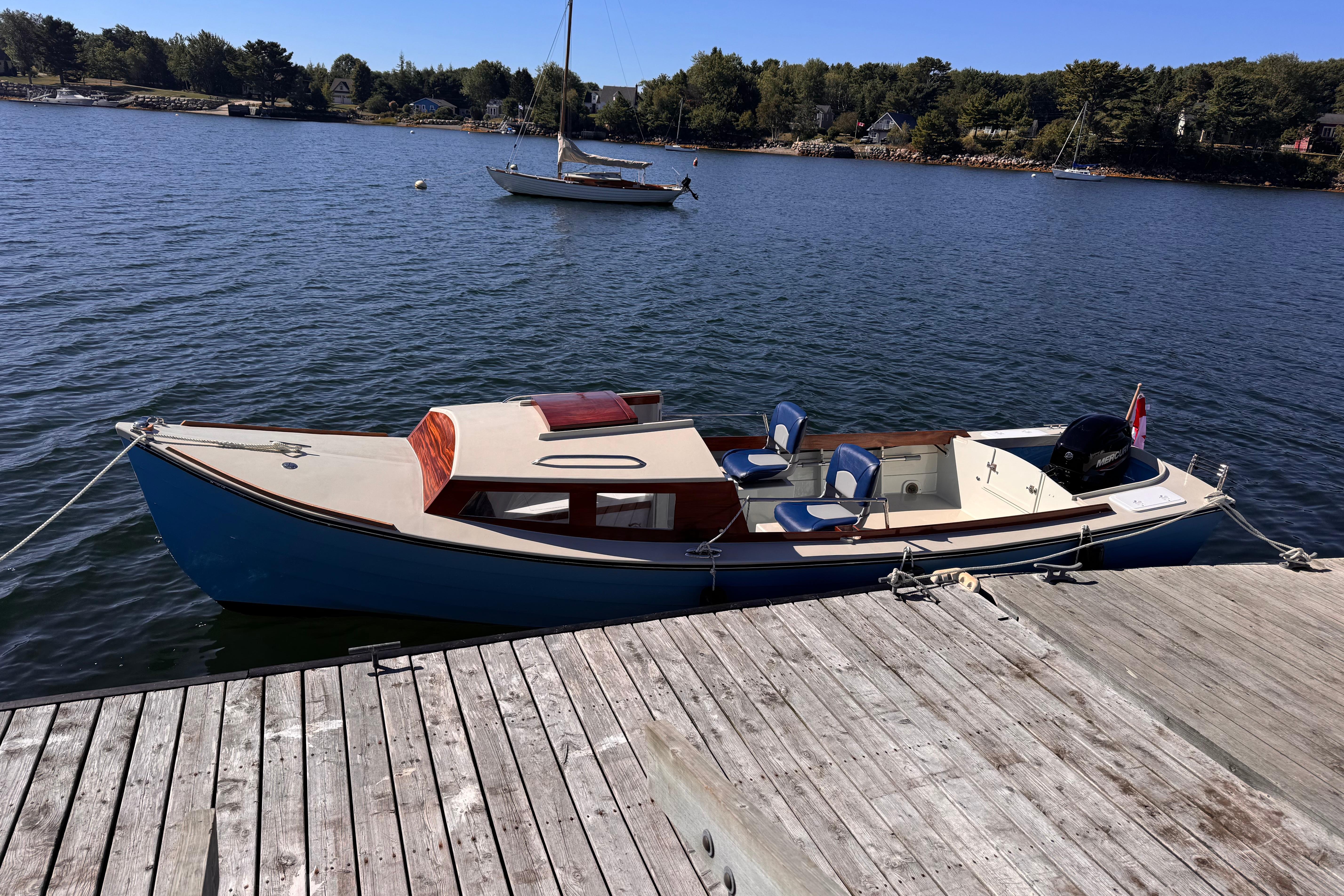 2024 Custom Ninigret 22 OB Skiff Cruiser docked on calm waters.