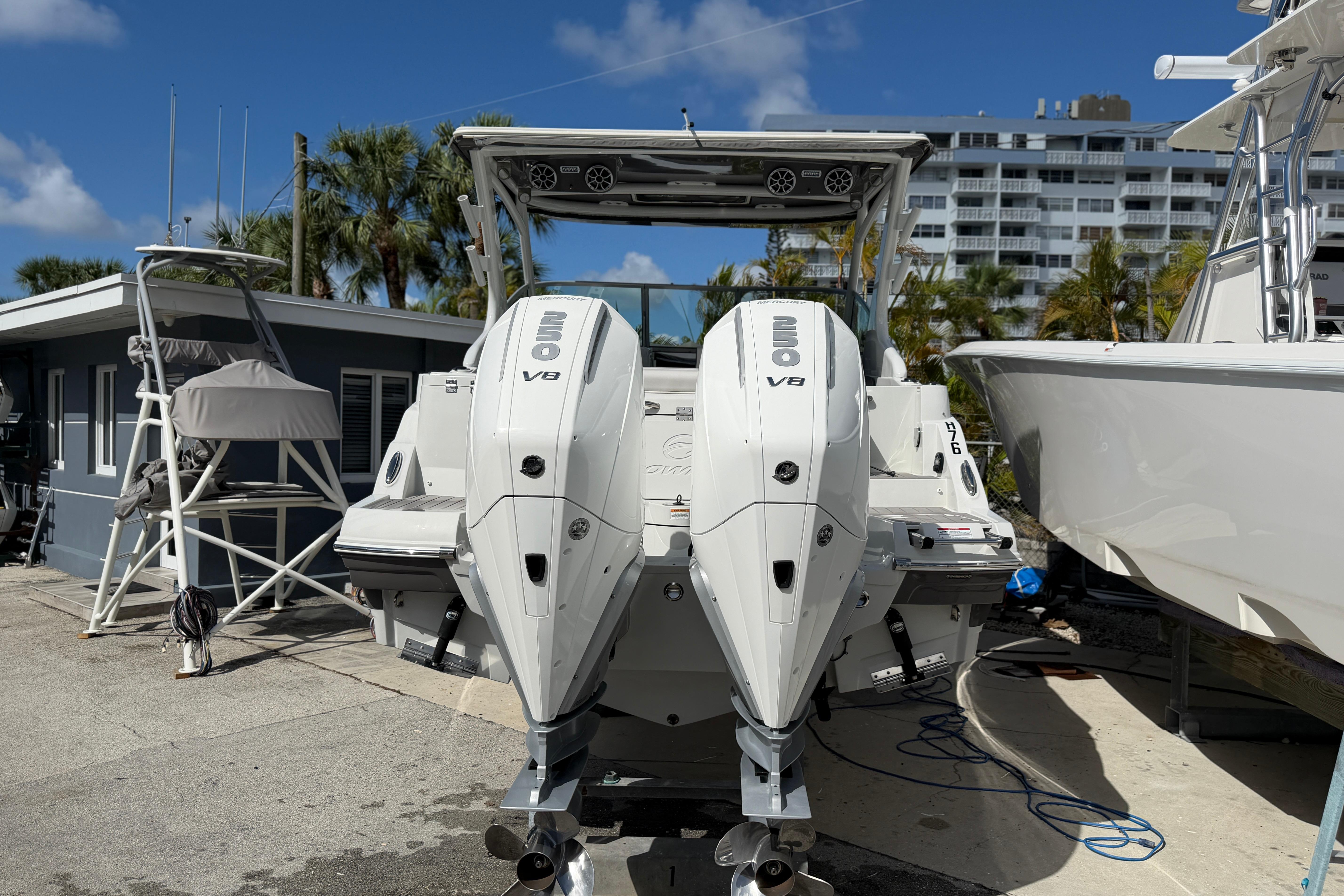 2024 Crownline 260 DC Finseeker with dual outboard engines at a marina.