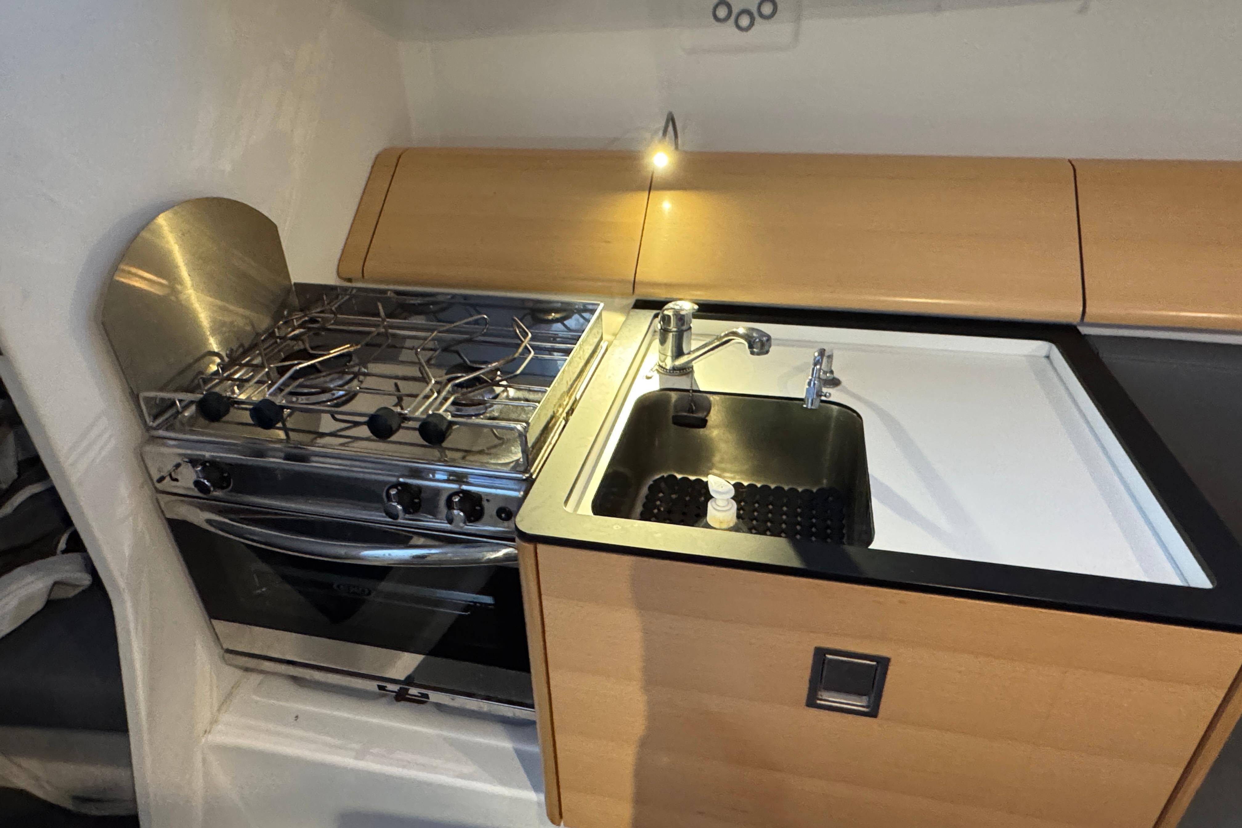 Compact kitchen in 2019 Pogo 36 yacht with stove and sink.