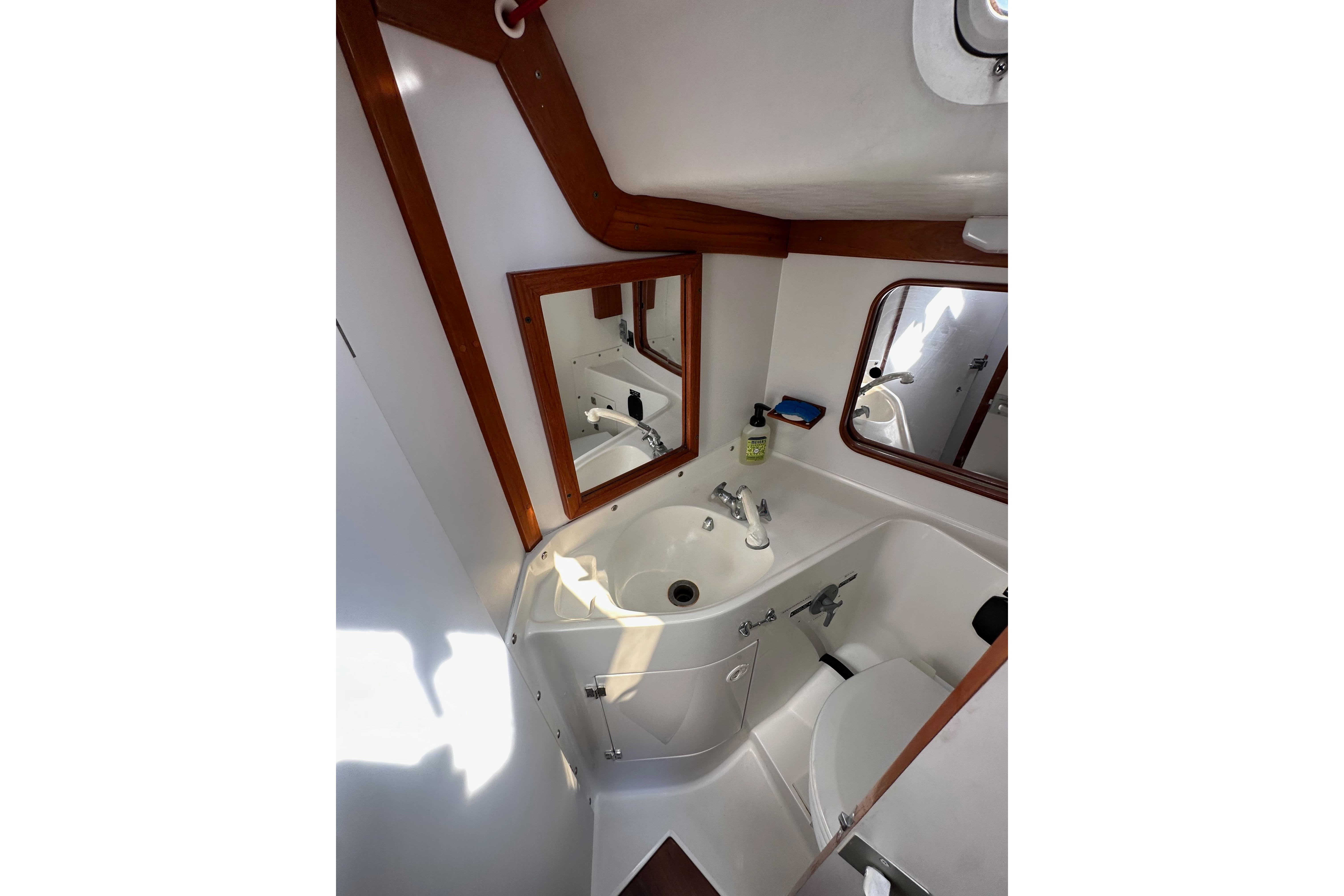 Bathroom interior of 1996 J Boats J/120 yacht with sink, mirror, and toilet.