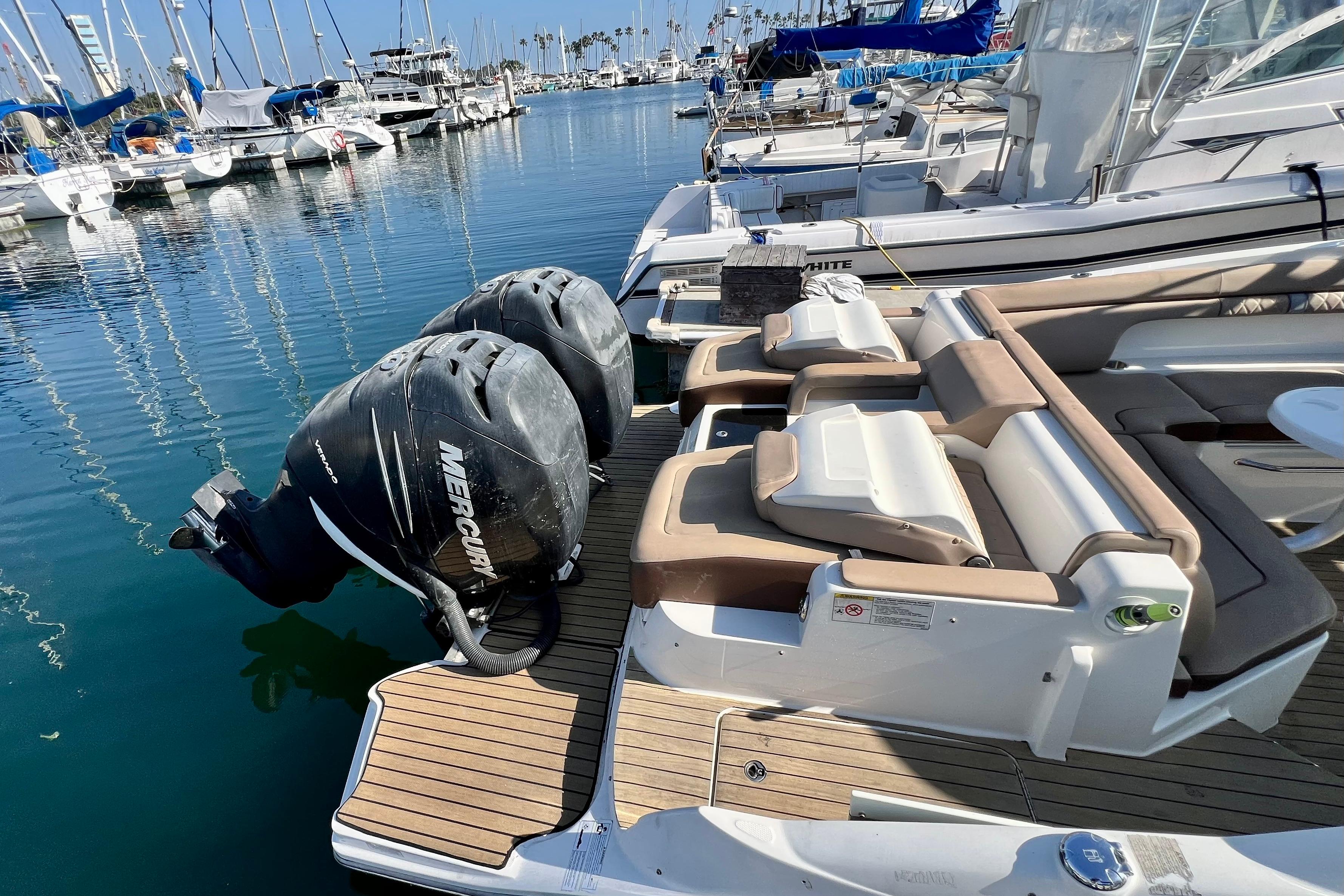 2016 Sea Ray 290 Sundeck Outboard with twin Mercury engines docked at marina.
