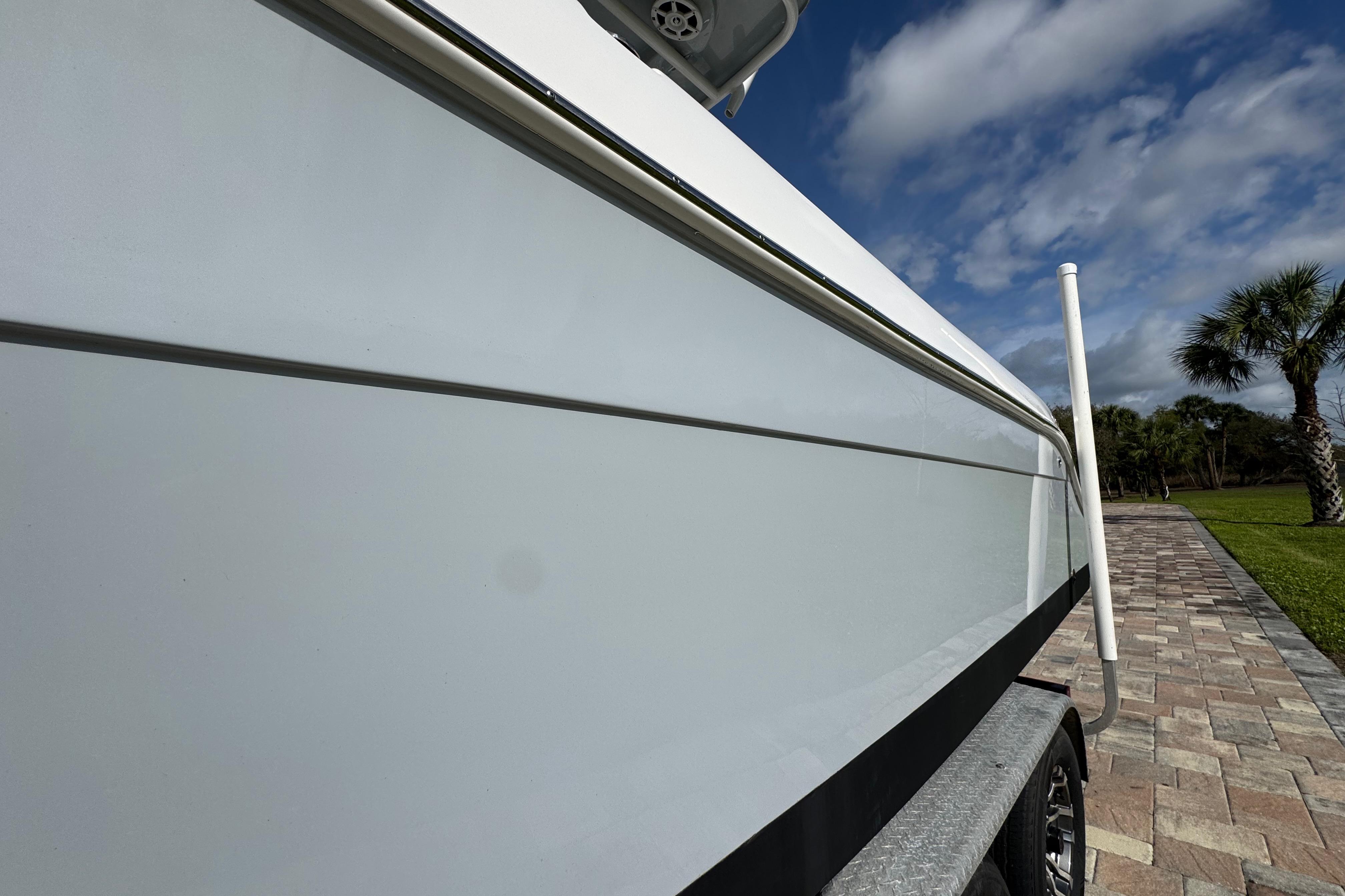 2022 Aquasport 2500 Center Console boat on trailer, under blue sky.