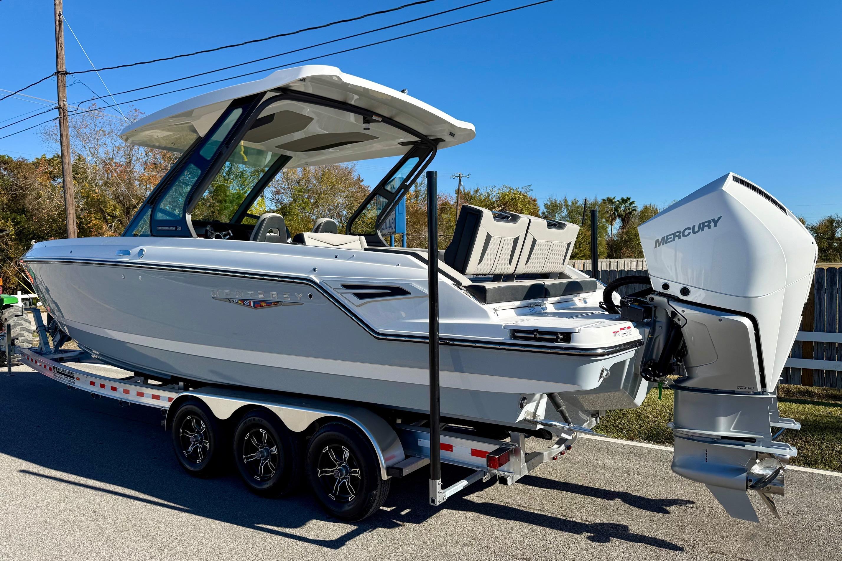 2026 Monterey Elite 30 OB boat on trailer, side view.