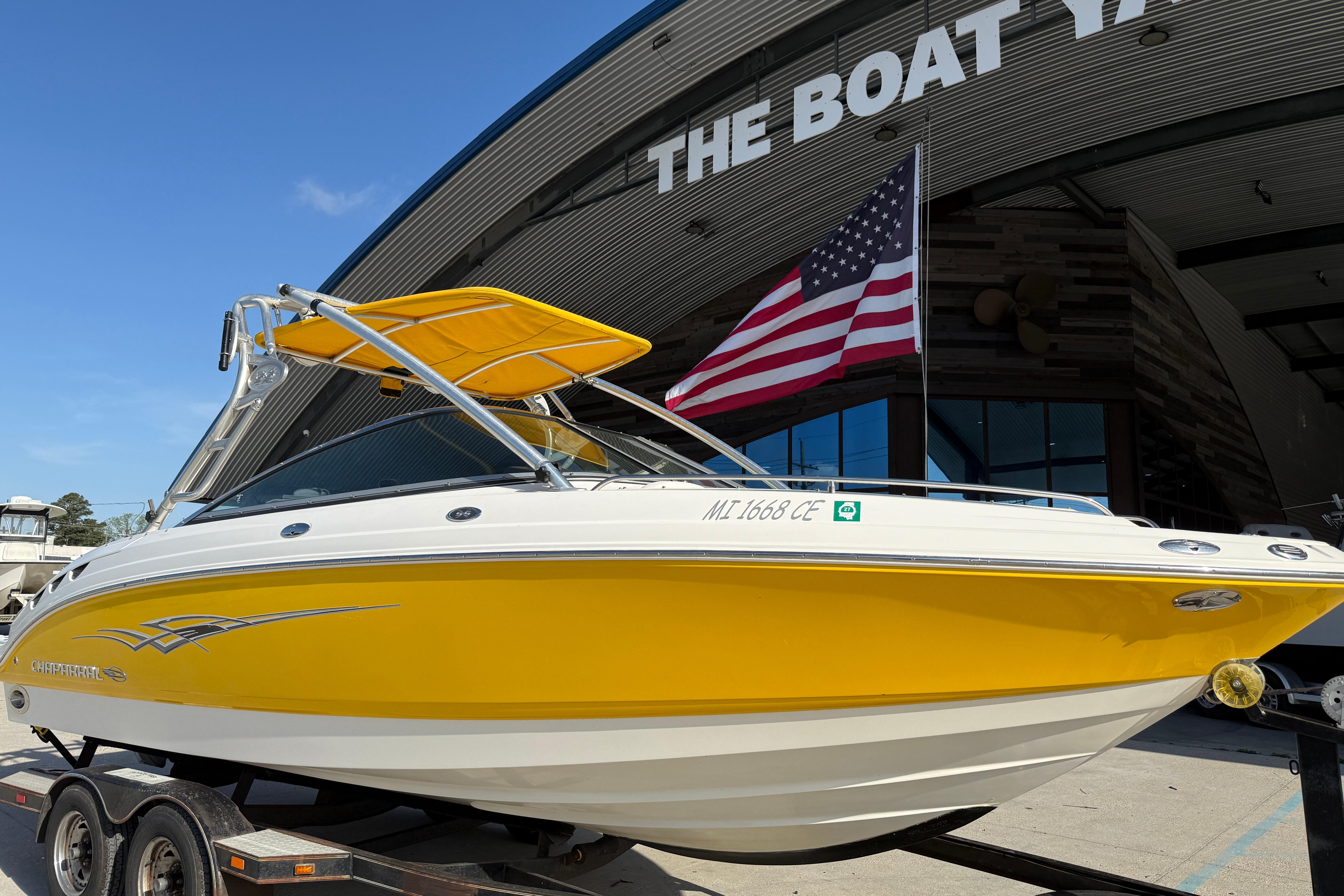 2008 Chaparral 236 SSX boat with yellow hull, displayed at a marina.