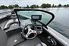 Interior view of 2023 Lund 1975 Tyee boat with steering wheel and navigation system.