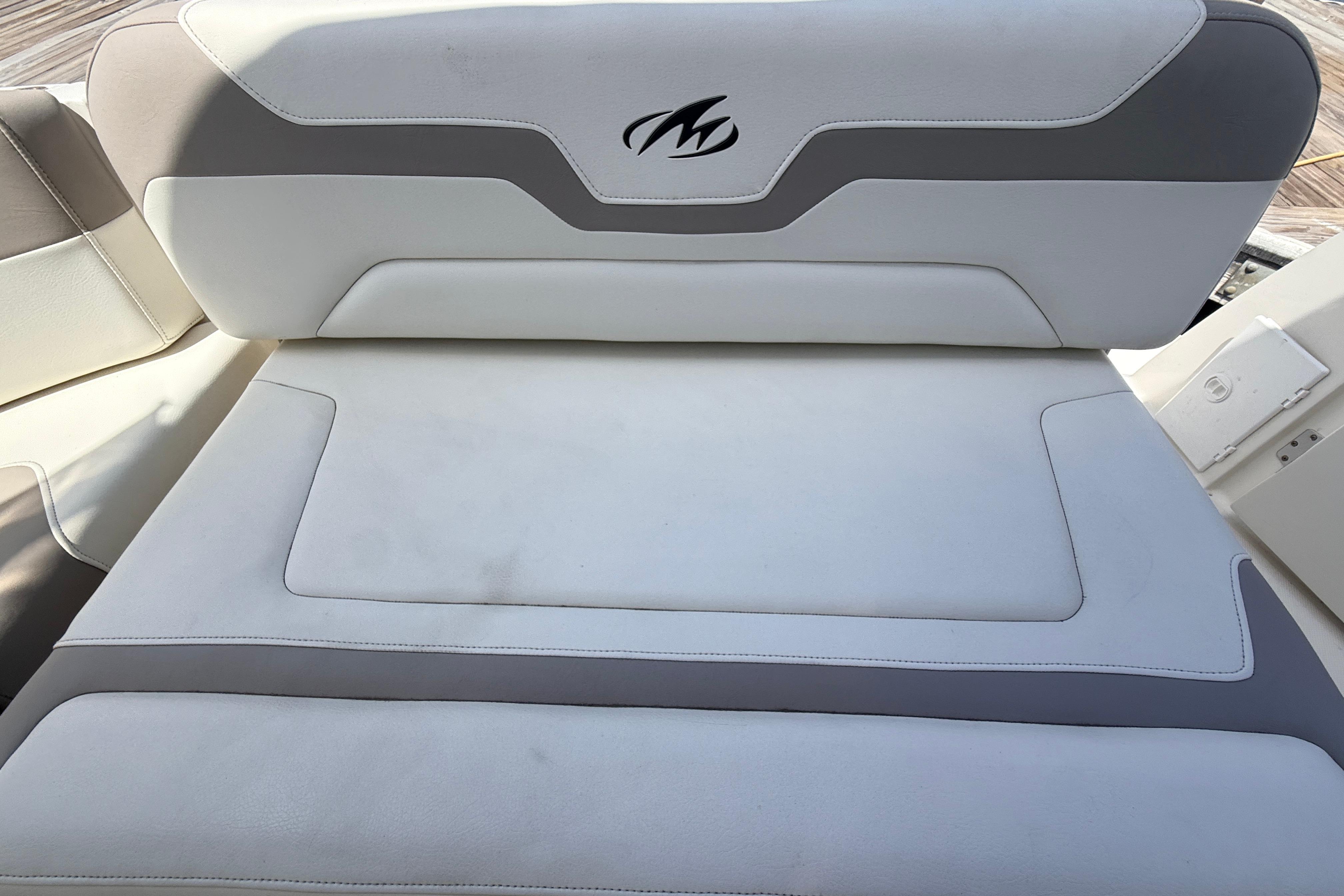 White and gray seating on 2011 Monterey 320 Sport Yacht, featuring logo detail.