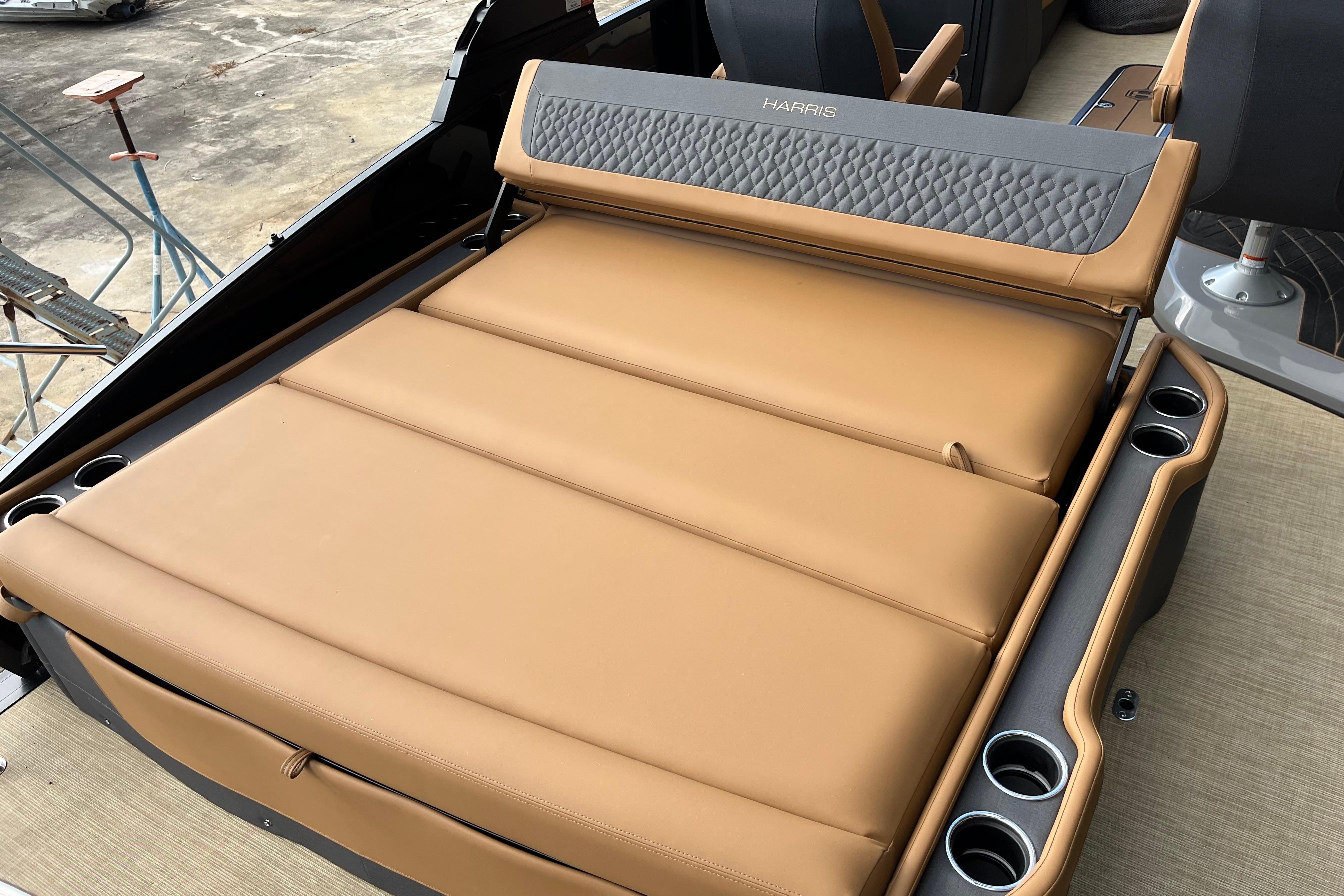 Luxurious seating on 2025 Harris Sunliner 250 boat with tan upholstery and cup holders.