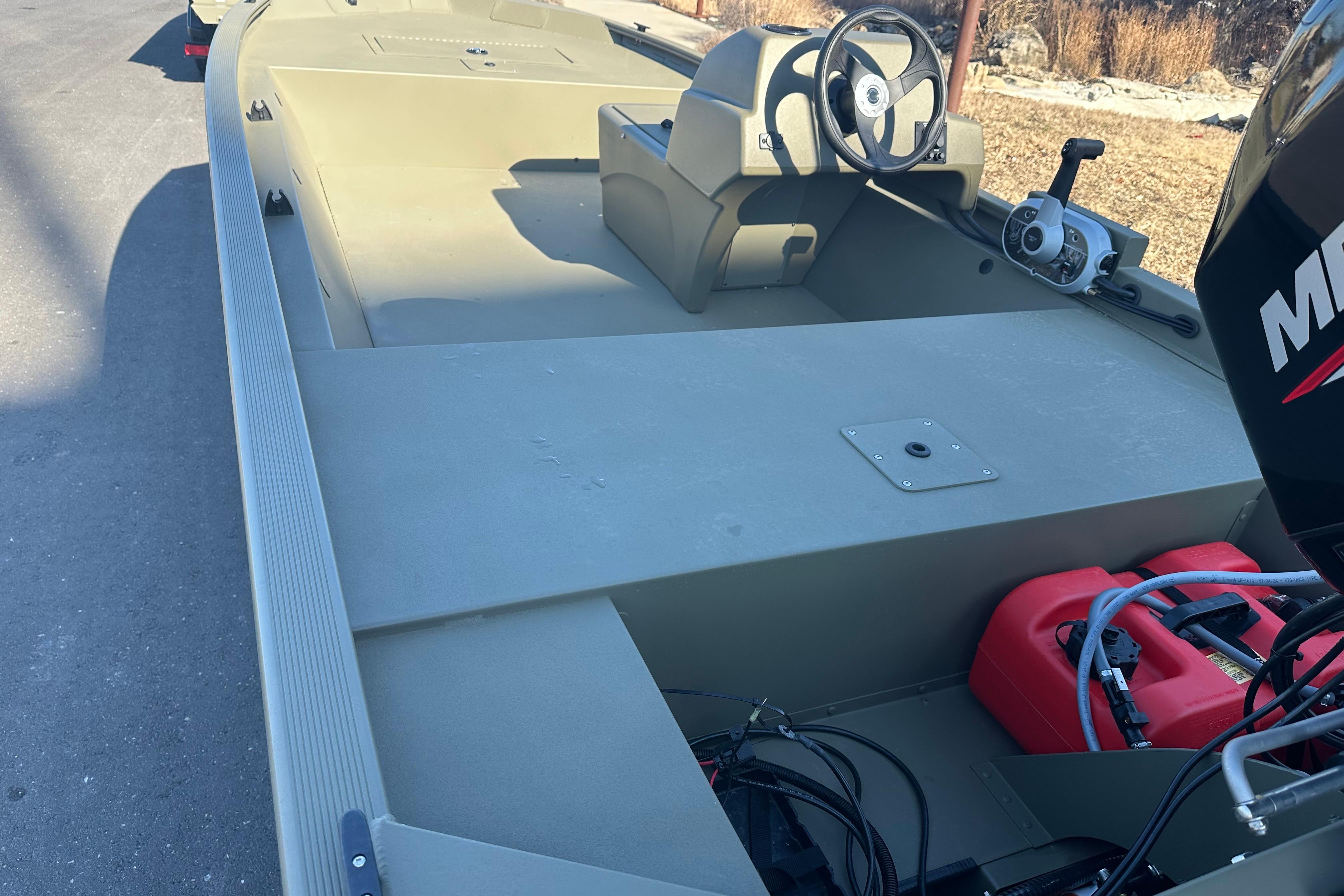 2026 Tracker Grizzly 1648 SC boat with steering console and outboard motor.