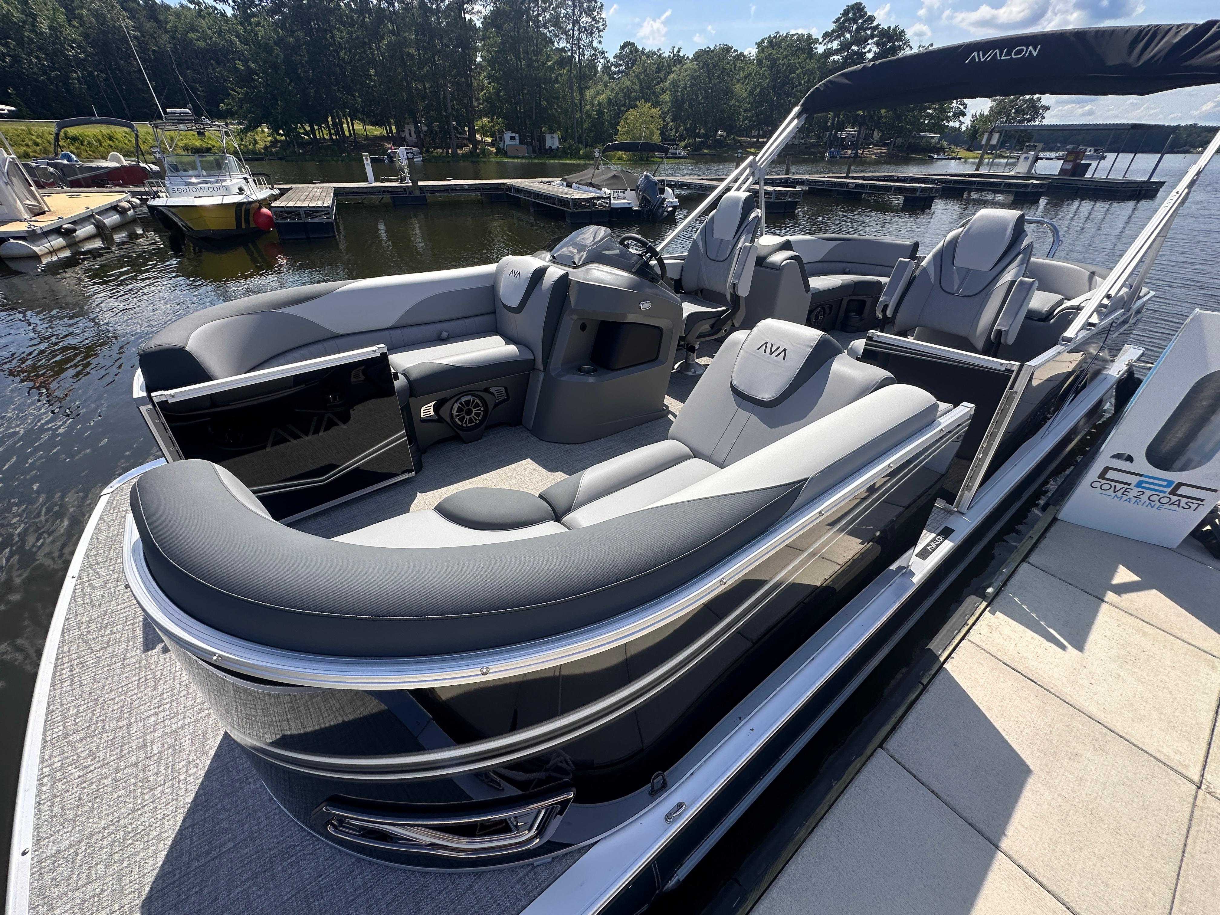 2025 Avalon LSZ Quad Lounger pontoon boat docked at a marina, featuring sleek design and comfortable seating.