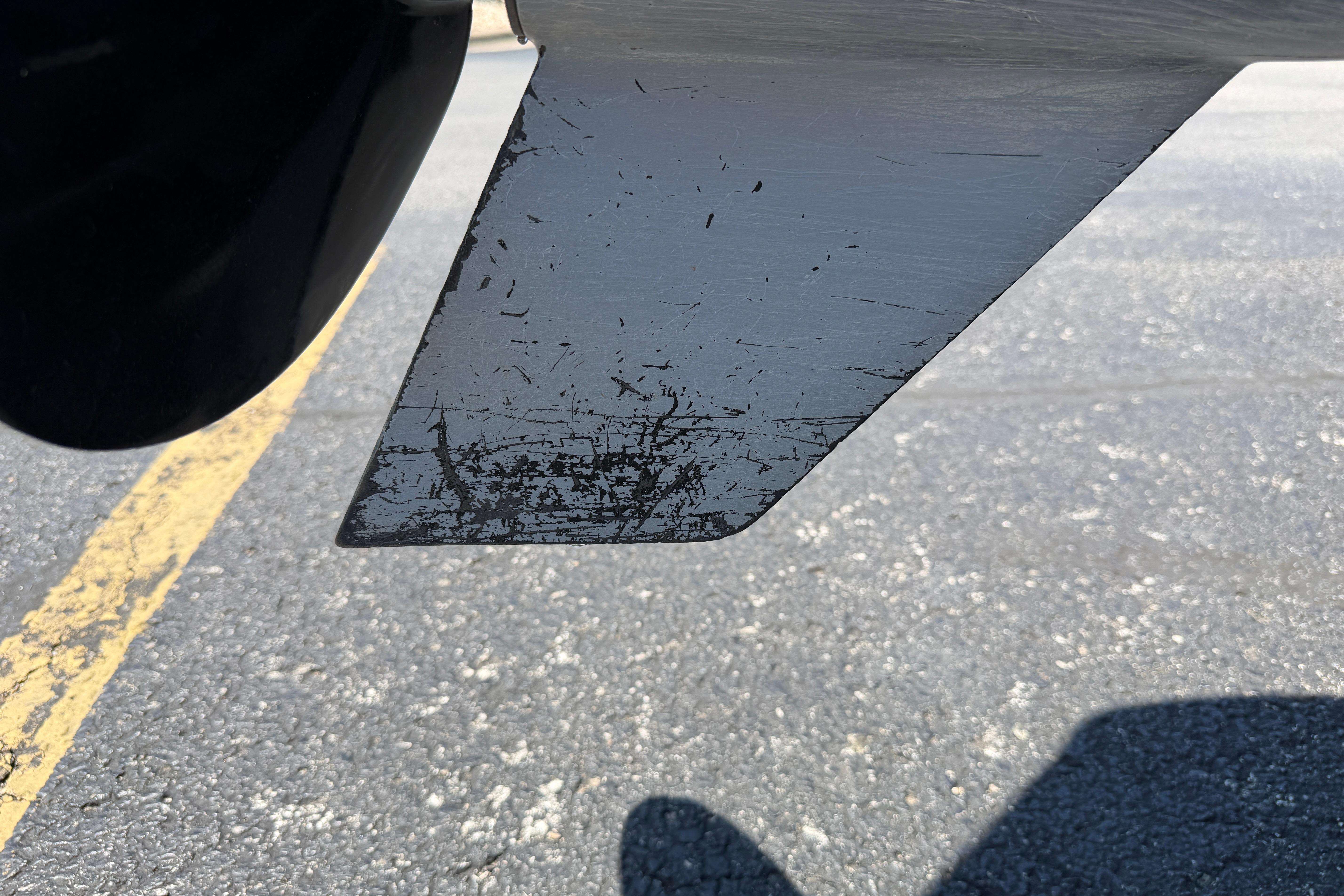 2024 Regency R250DL3 boat propeller with visible wear and scratches on asphalt background.