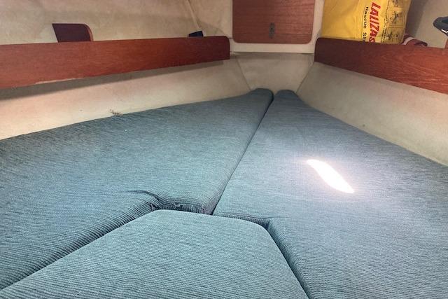 Interior cabin of 1988 Westerly Corsair 36 sailboat with blue cushions.