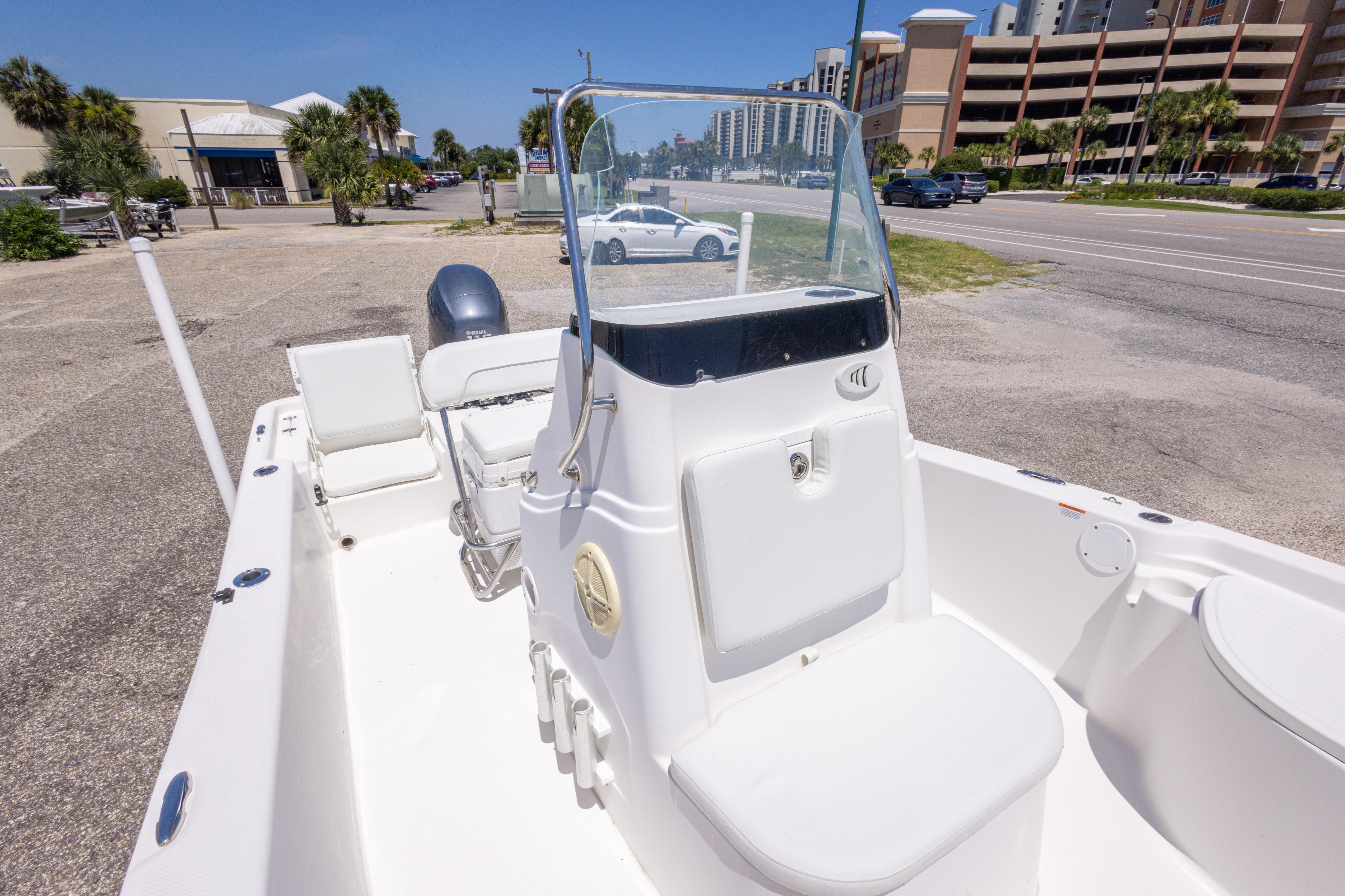 2011 Sea Fox 200XT boat with center console, parked near a road and buildings.