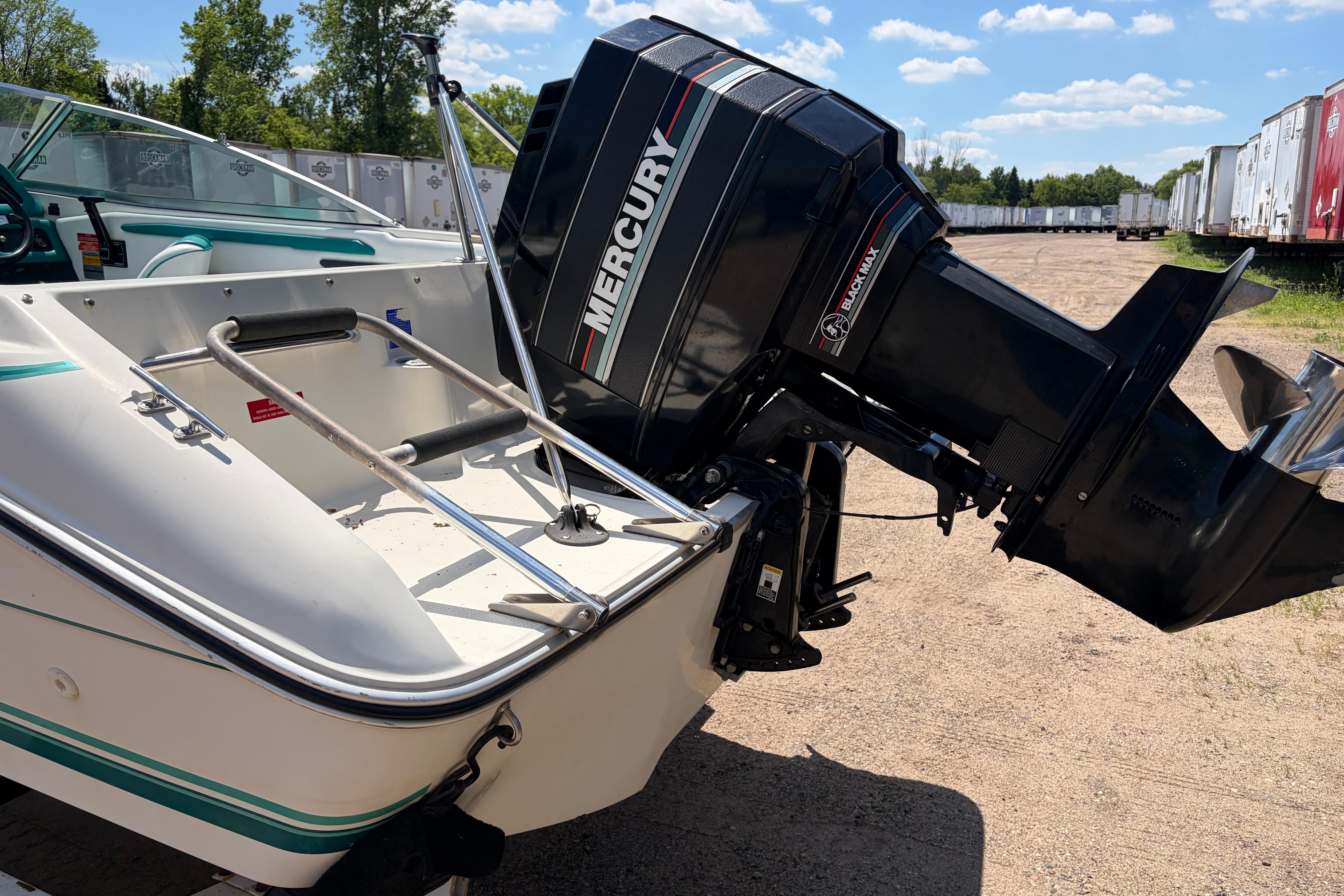 1990 Sea Ray 180 Bow Rider with Mercury outboard motor, parked outdoors on a sunny day.