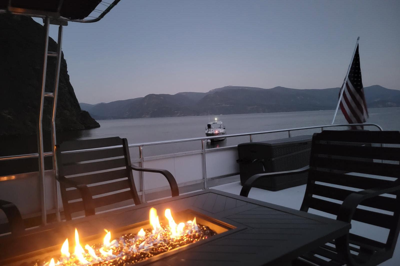 Luxurious 2015 Sailabration 64 yacht with fire pit, lake view, and American flag.