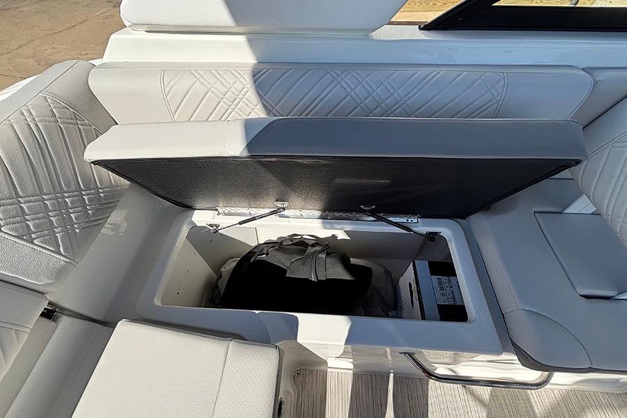 2027 Sea Ray SDX 230 Outboard boat interior storage compartment with open lid.