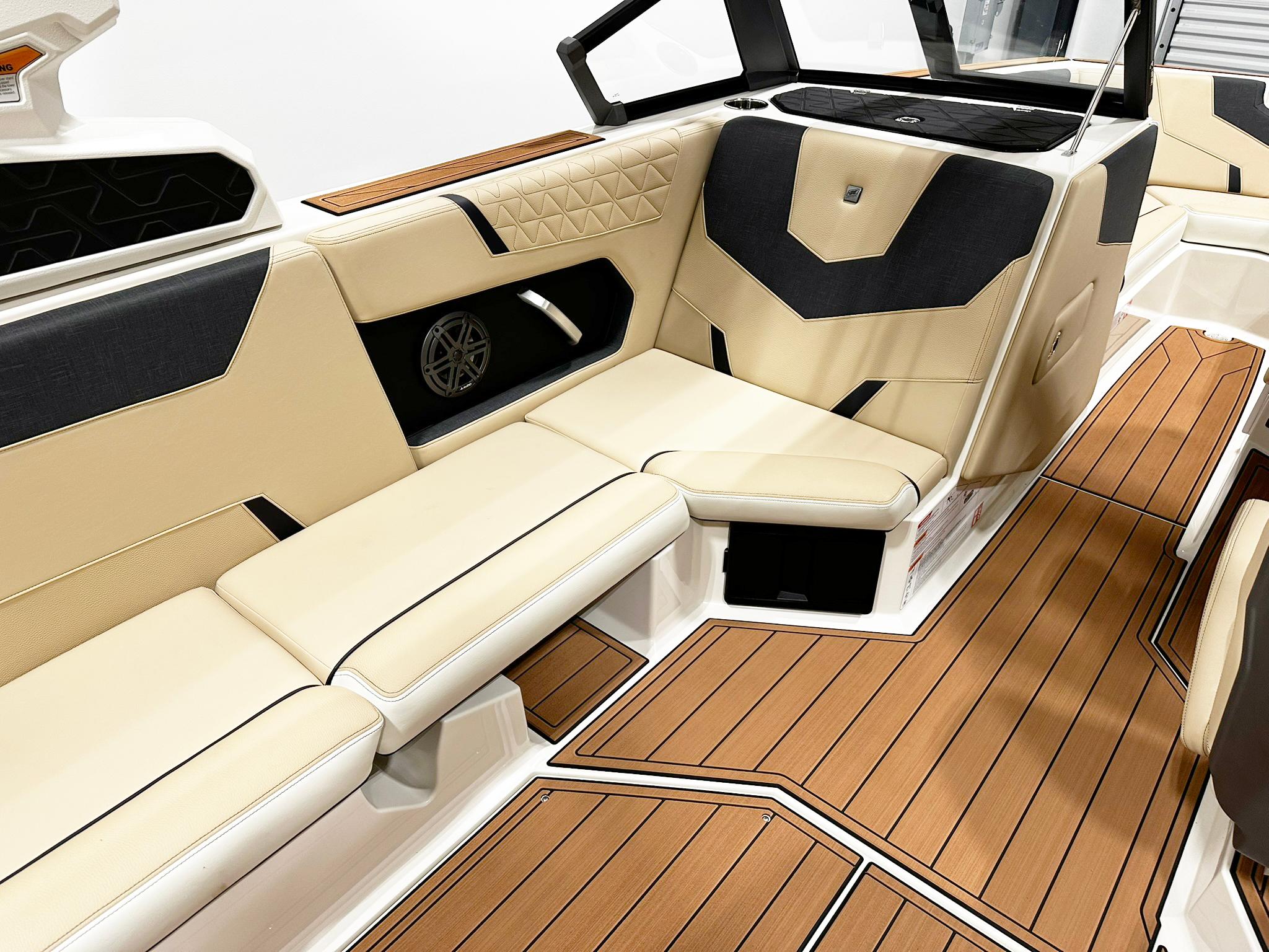 2026 Nautique GS24 boat interior with beige and black seating, teak-style flooring.