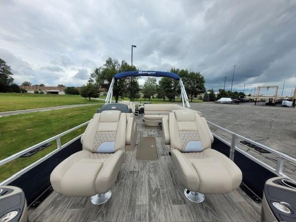 2024 Ranger Reata 223F boat with plush seating and open deck, under cloudy skies.