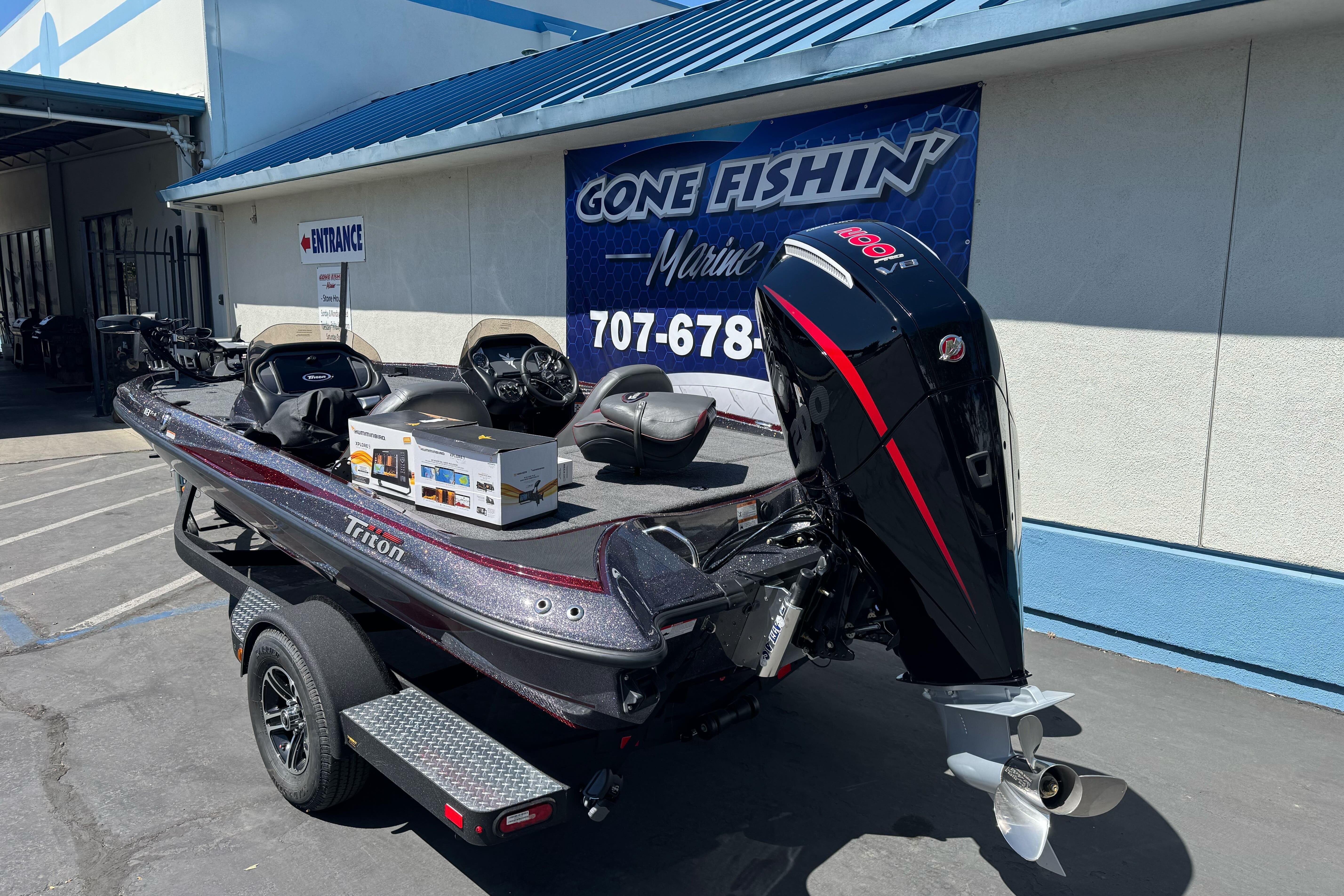 2026 Triton 18 TrX boat with powerful outboard motor at dealership.
