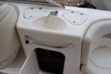 2002 Chaparral Sunesta 263 boat interior with sink and storage compartments.