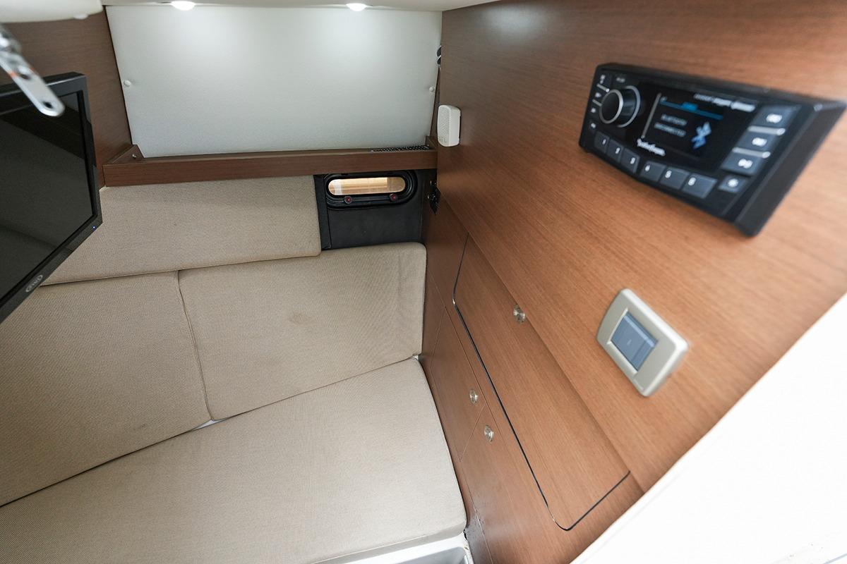 2018 Sea Ray SLX 350 cabin interior with beige seating, wood paneling, and modern audio system.