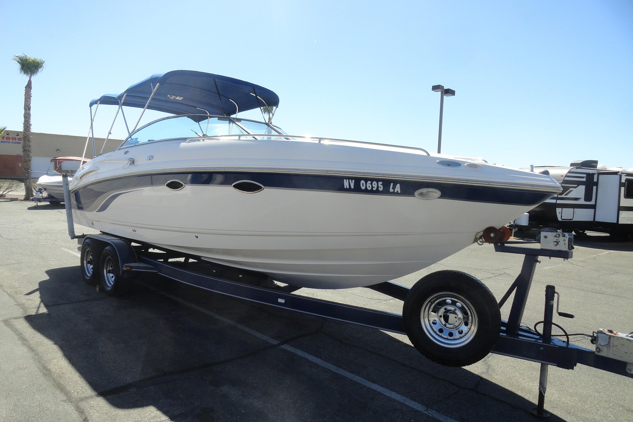 2001 Chaparral 265 SSi boat on trailer, parked outdoors under clear sky.
