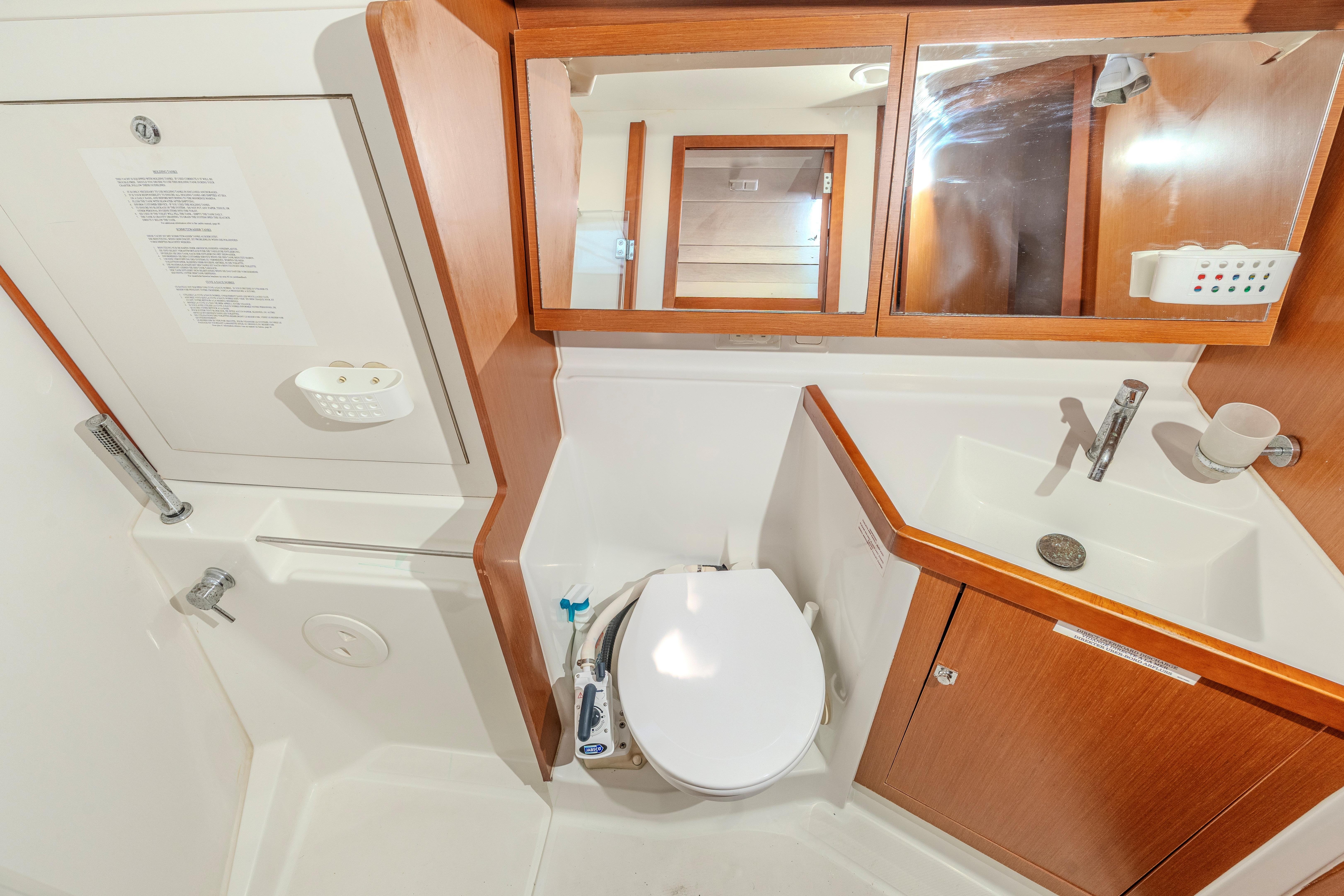 Beneteau Oceanis 41 bathroom interior, featuring a toilet, sink, and wooden cabinetry, 2013 model.
