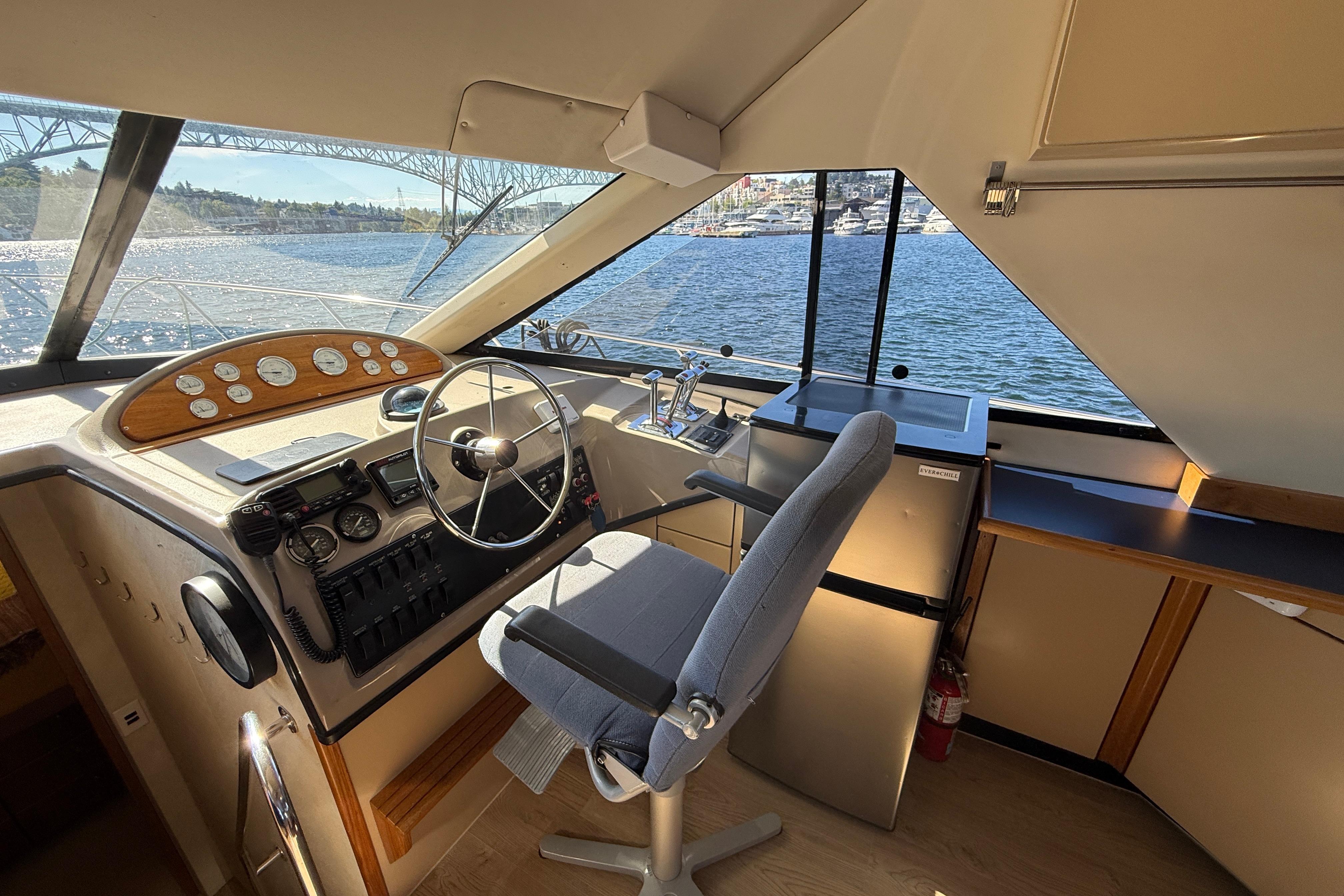 1997 Bayliner 3988 Command Bridge Motoryacht helm with steering wheel, controls, and scenic water view.