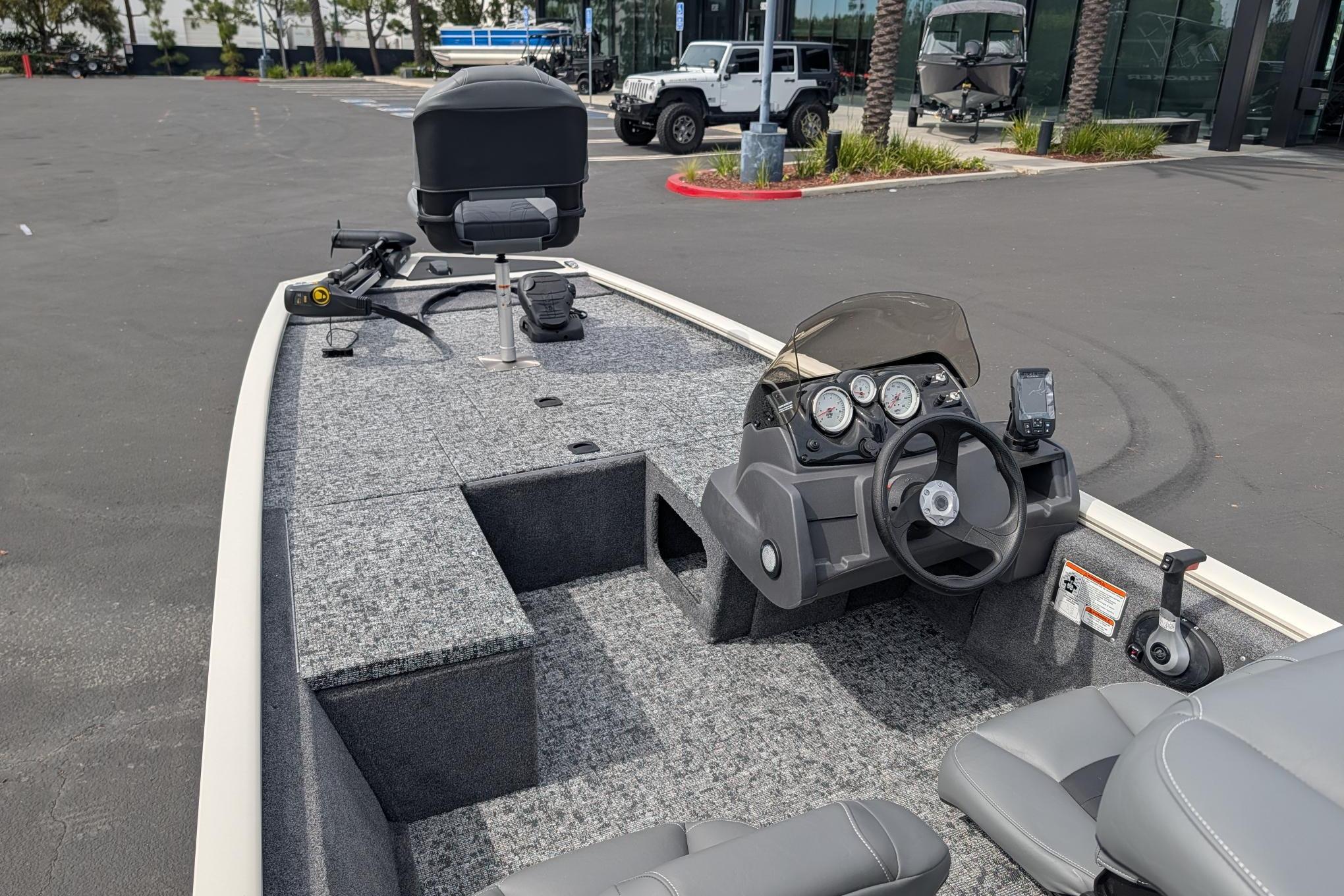 2026 Tracker Pro 170 boat interior with steering console and seating in a parking lot.
