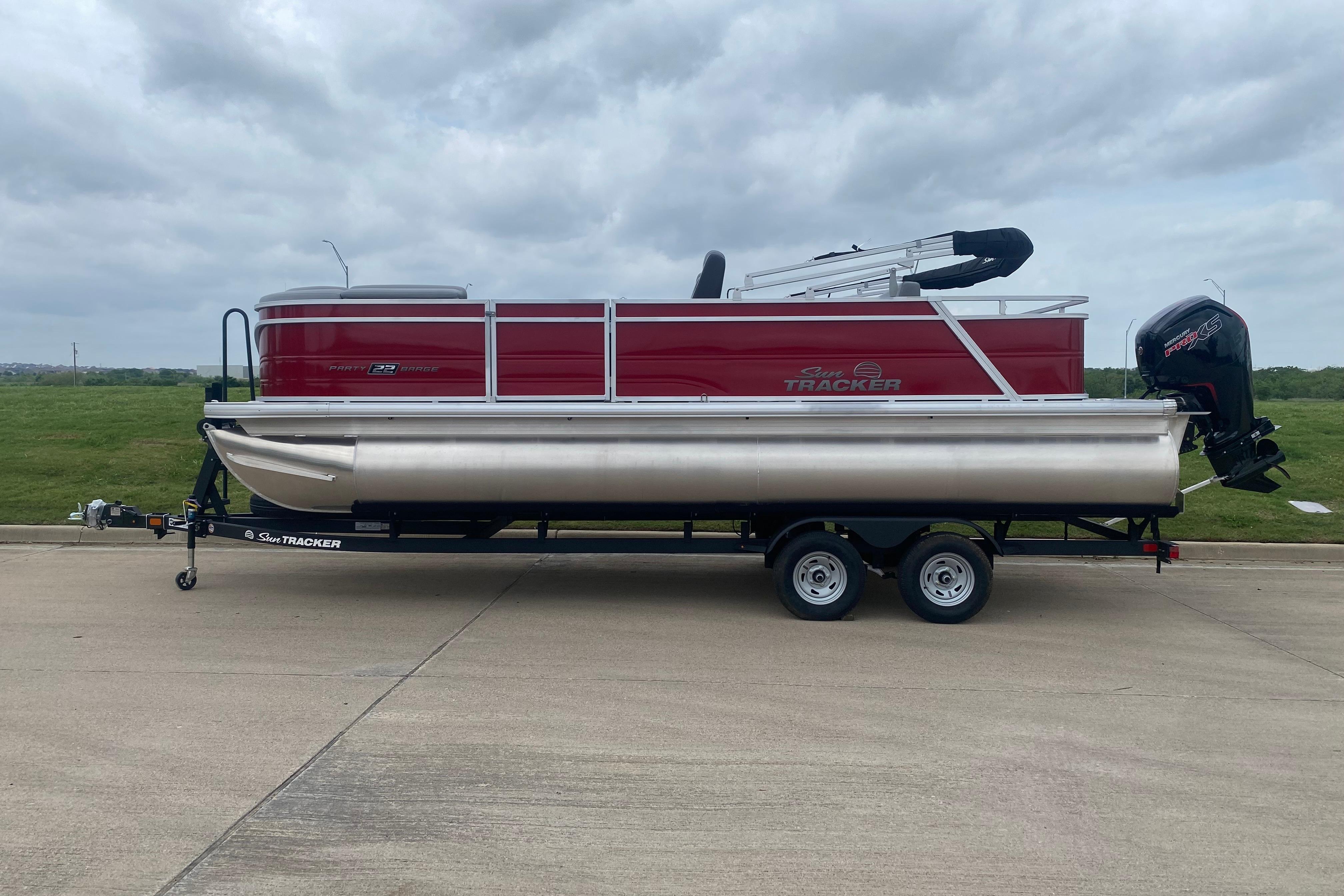 2026 Sun Tracker Party Barge 22 RF DLX pontoon boat on trailer, side view.