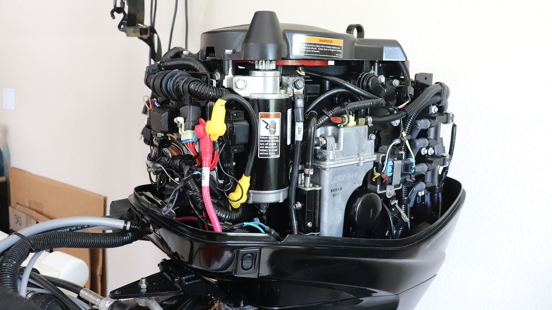 Close-up of a boat outboard motor with visible wires and components.