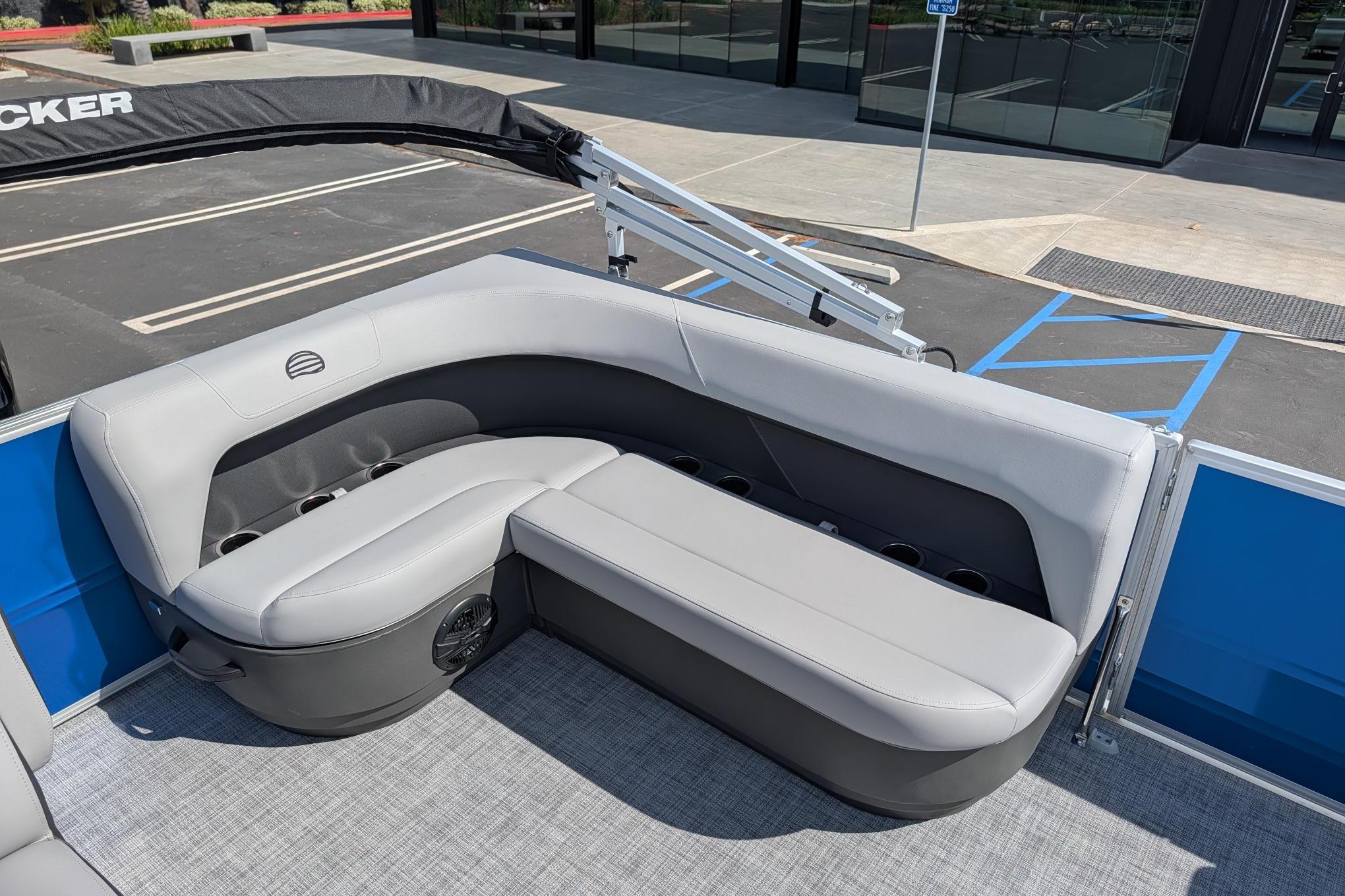 2026 Sun Tracker Party Barge 16 DLX interior with gray seating and cup holders.